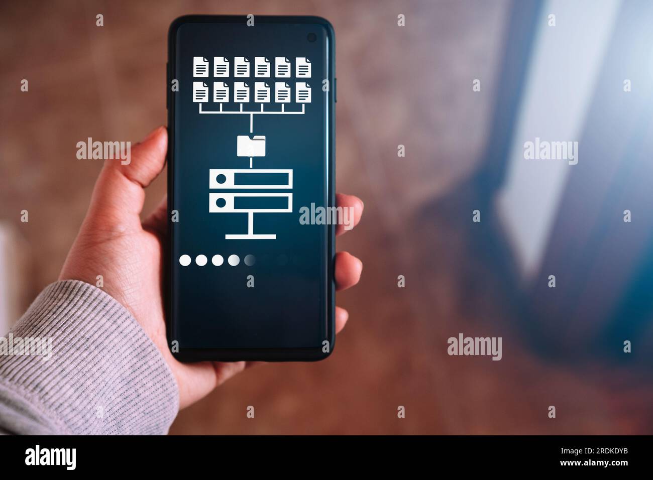 Weibliche Hand zeigt Datenspeicher auf dem Smartphone-Bildschirm. Symbol für das Konzept des Informationsaustauschs und -Transfers. Stockfoto