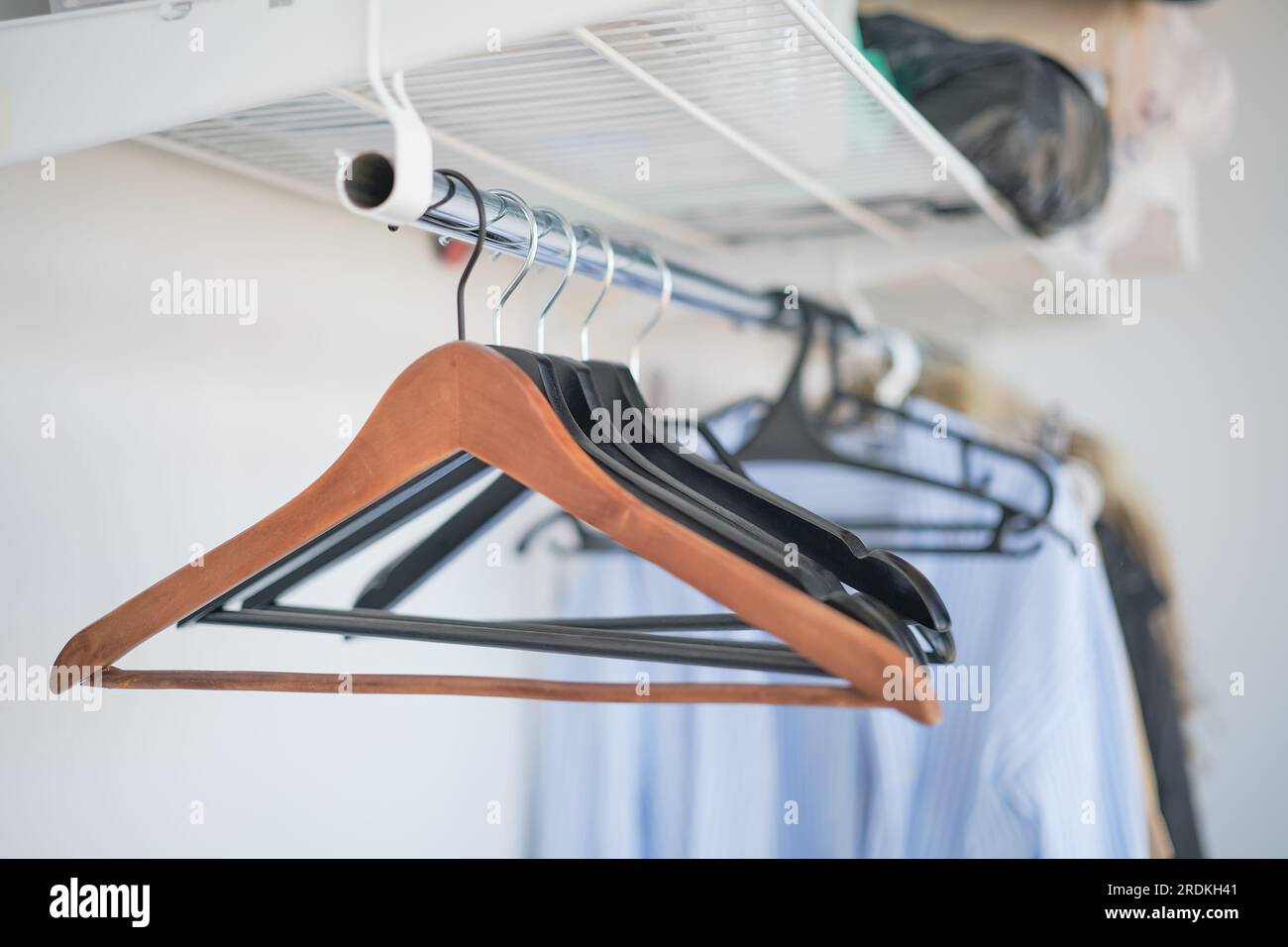 Leere Kleiderbügel an einem Kleiderbügel im Schrank, Idee für einen Hintergrund oder Werbung für einen Verkauf. Selektiver Fokus Stockfoto