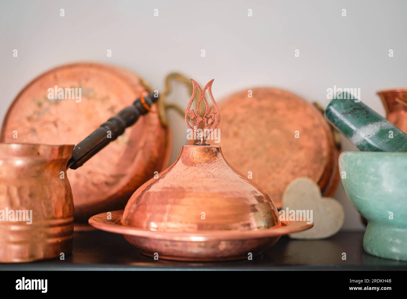 Traditionelle kupferfarbene türkische Utensilien auf einem Regal in der Küche zu Hause oder in einem Restaurant, selektiver Fokus. Traditionelles Kunsthandwerk. Stockfoto
