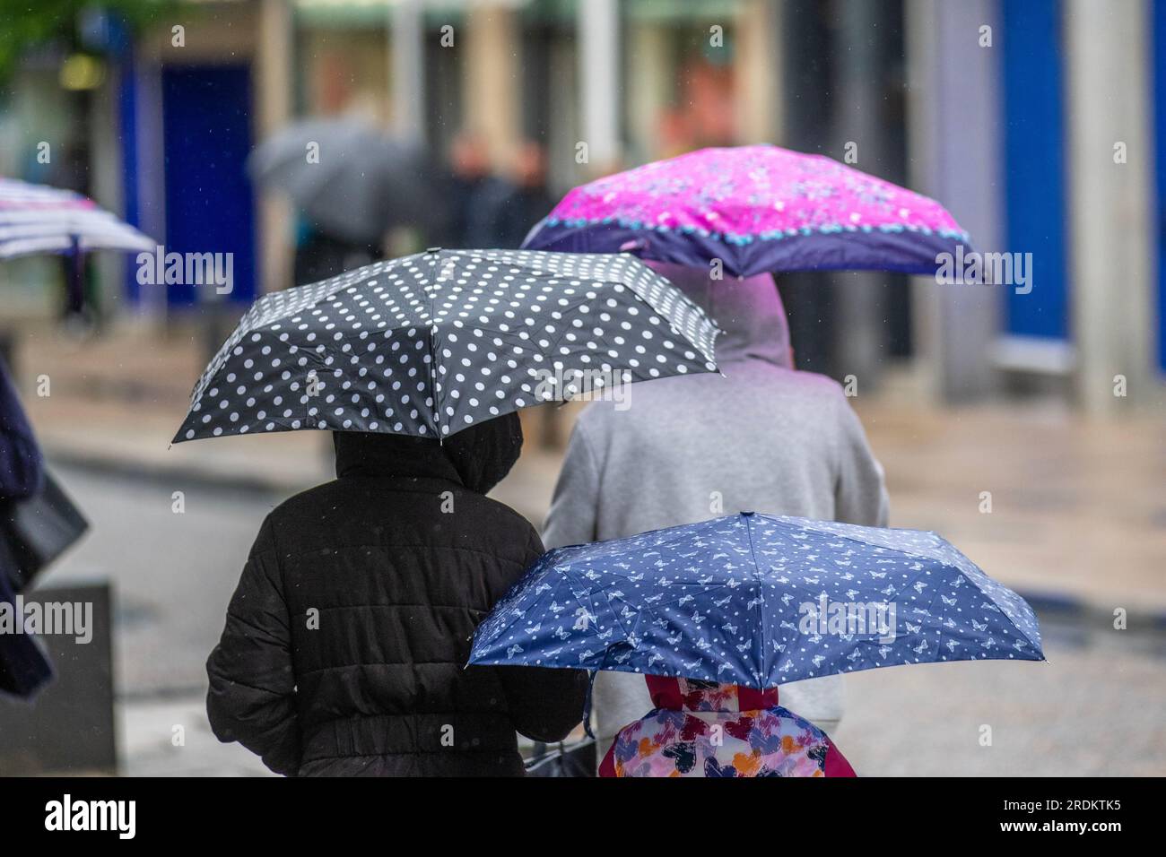 Alle Käufer halten Regenschirme bei einem Regen in Preston Lancashire. Wetter in Großbritannien 22. Juli 2023. Sommerverkäufe, Geschäfte und Shopper an einem regnerischen Tag im Stadtzentrum. Laut Wettervorhersage: „Regen, manchmal stark, bis Samstag und Sonntag, wird wahrscheinlich einige Störungen verursachen, insbesondere bei Outdoor-Veranstaltungen. Stockfoto