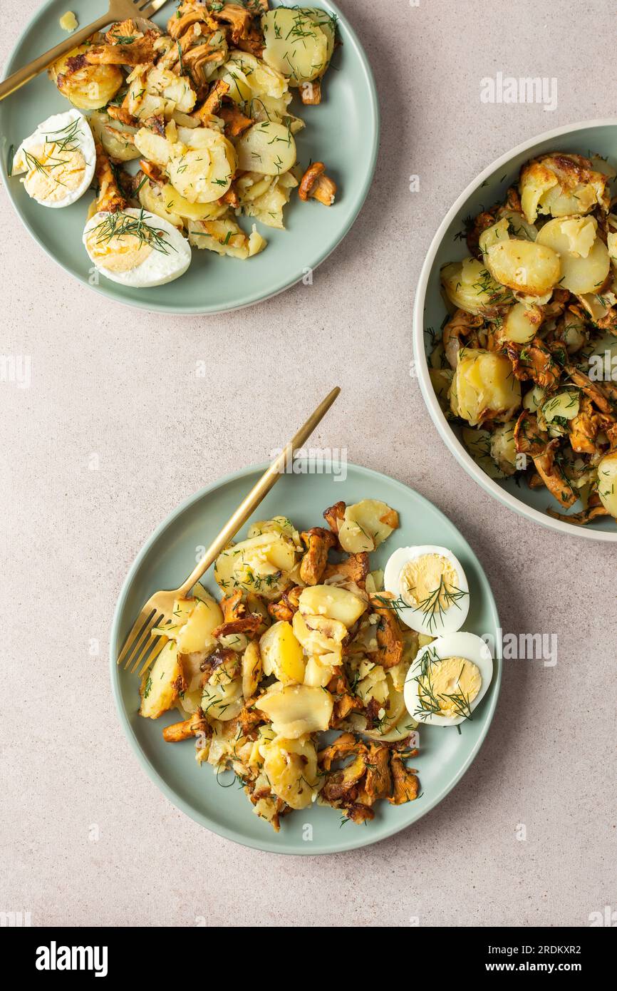 Köstliche herzhafte Abendessen oder Mittagessen, gebratene junge Kartoffeln mit Waldpilzen Chanterelles mit Dill, gekochte Eier, saisonale Speisen Stockfoto