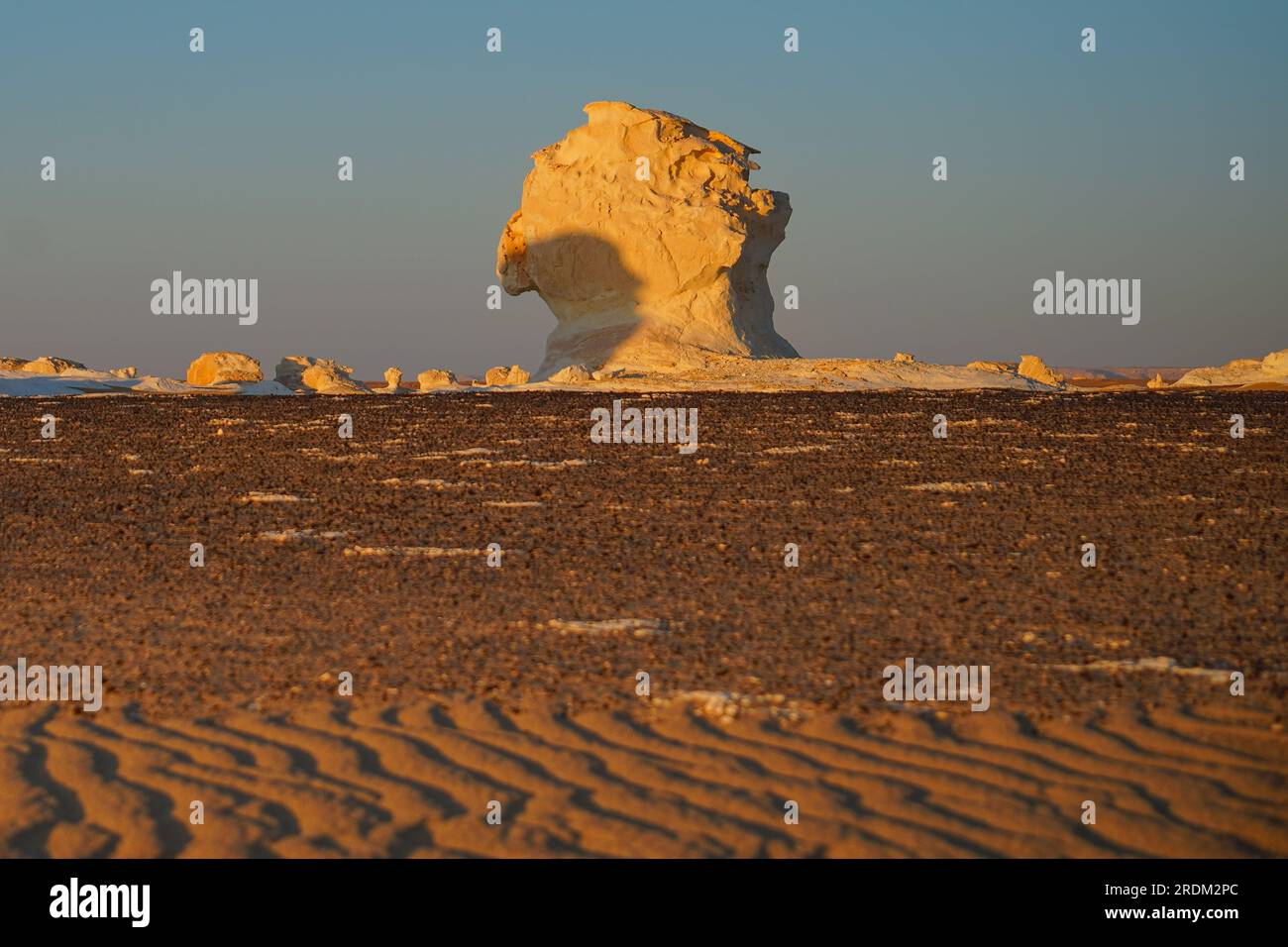 Sonnenuntergang in der Weißen Wüste, Ägypten. Von der Erosion von Vulkanen und einem Quarzberg bis hin zu verwitterten Felsen und weißen Kreidefelsen ist die Schwarze und Weiße Wüste Teil der Frarafra-Depression in der Sahara und liegt im westlichen Teil Ägyptens. Die weite Wüste führt zu den Hauptstraßen in der Nähe der libysch-ägyptischen Grenze, wo sie jetzt mit militärischer Präsenz schwer bewaffnet ist. Die bizarre natürliche Landschaft, die vor Millionen Jahren von einem Meeresboden aufstieg, ist jetzt mit Karstkalkstformationen übersät, die der Oberfläche anderer Planeten im Universum ähneln. Stockfoto