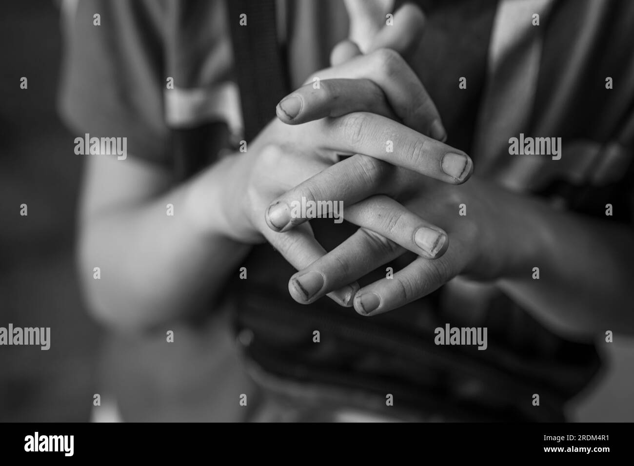 Nahaufnahme der Hände des Jungen. Die Hände eines Gartenjungen. Lange Fingernägel und Schmutz unter den Nägeln. Unordentliche Kinderhände. Schwarzweißbild. Stockfoto