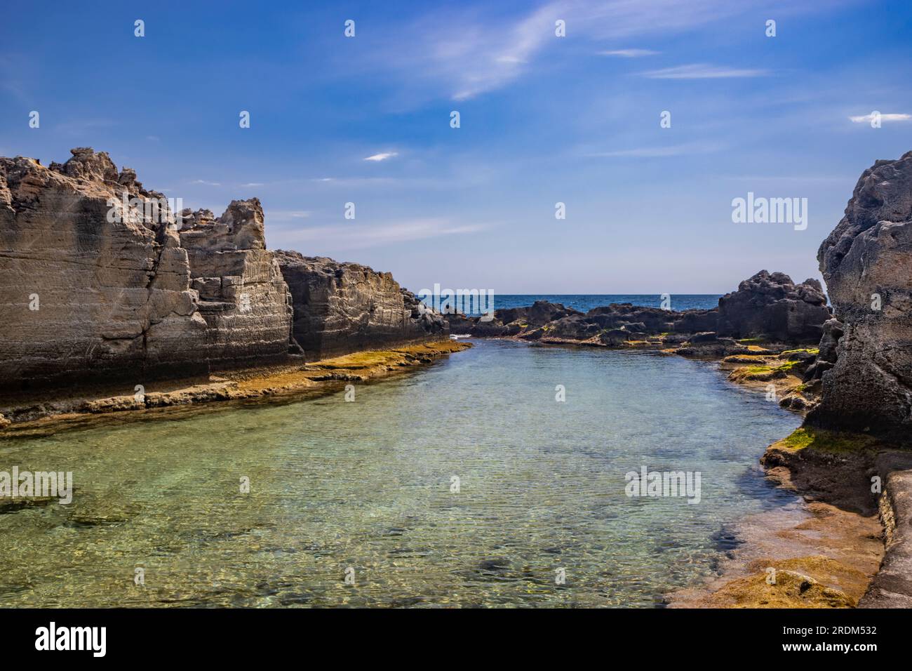 Die fantastischen natürlichen Pools von Marina Serra, in Apulien, Salento, Tricase. Das klare und kristallklare türkisfarbene Meer zwischen den felsigen Klippen. Der blaue Himmel Stockfoto