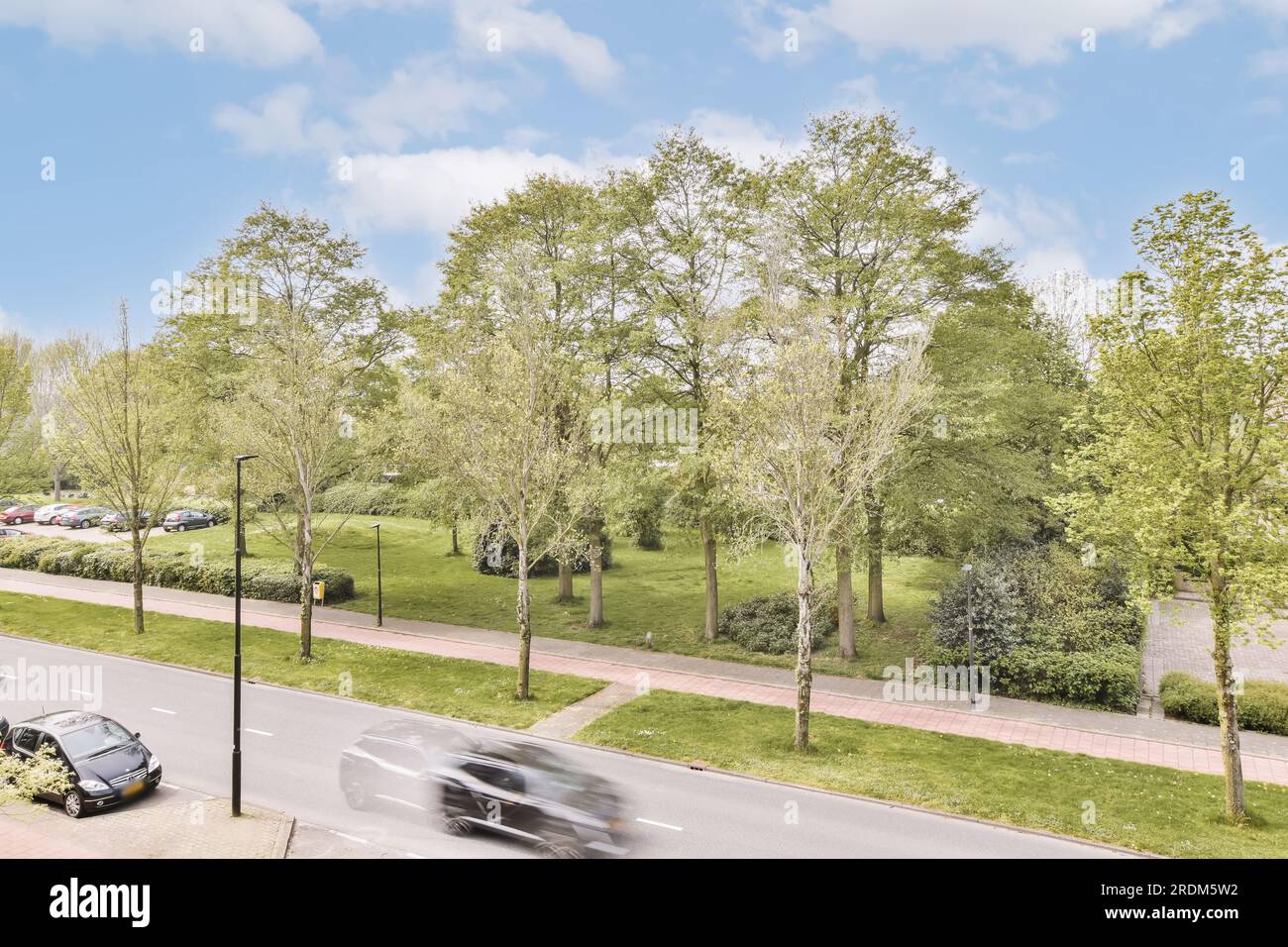 Eine leere Straße mit Autos, die auf der Straße fahren und Bäume im Vordergrund - Bild von google Street View Stockfoto