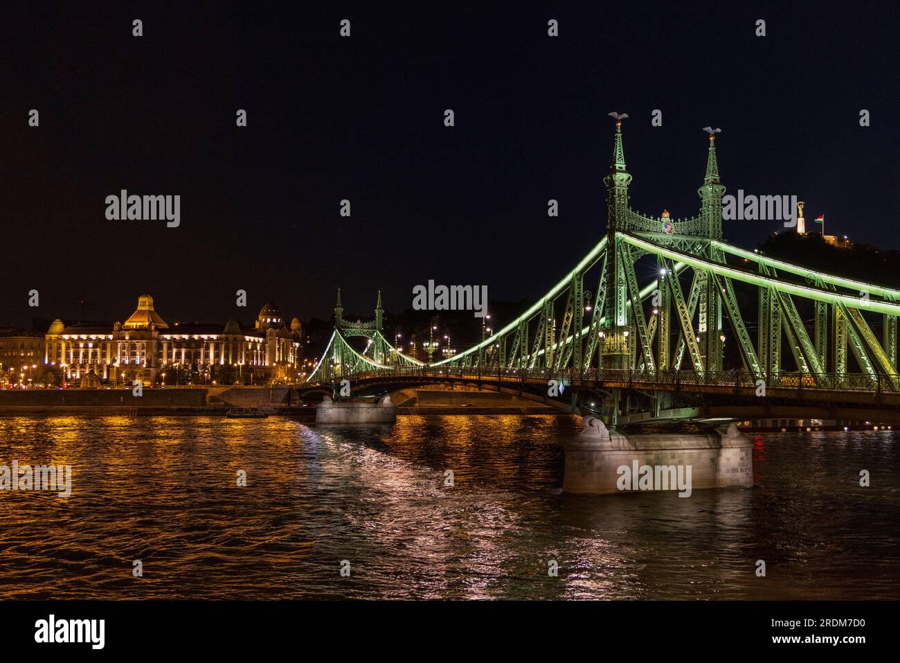 Die beleuchtete Freiheitsbrücke über der Donau zwischen Buda und Pest mit dem Gellert Hotel im Hintergrund, Budapest, Ungarn Stockfoto