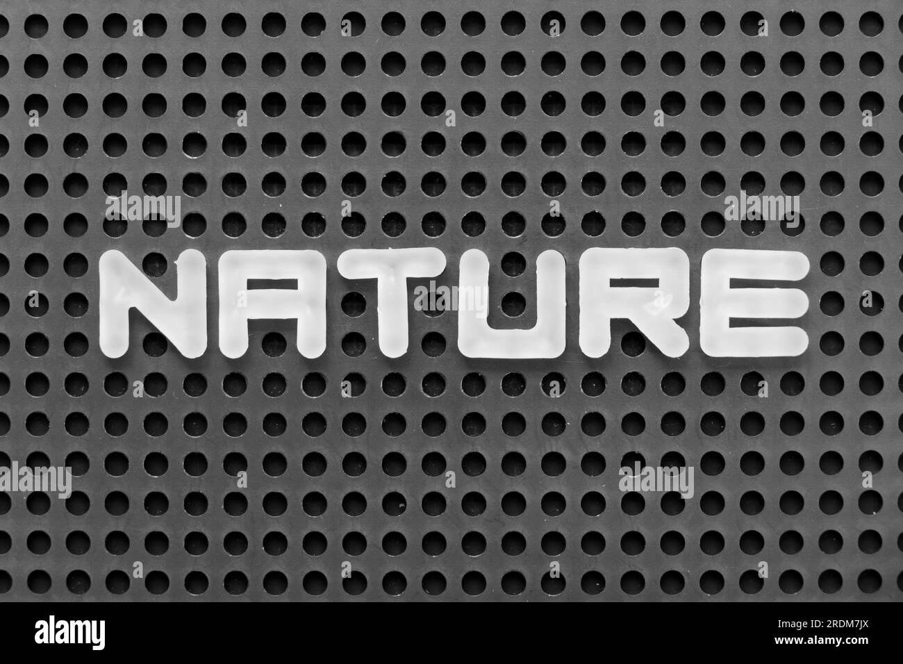 Weißer Buchstabe in Wortwahl auf schwarzem Hintergrund mit Lochwand Stockfoto