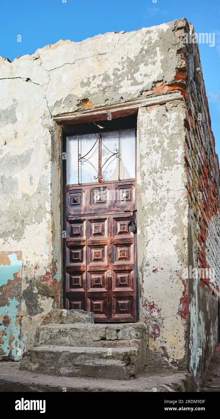 Blick auf eine alte Gebäudefassade mit Metalltür, Latacunga, Ecuador. Stockfoto