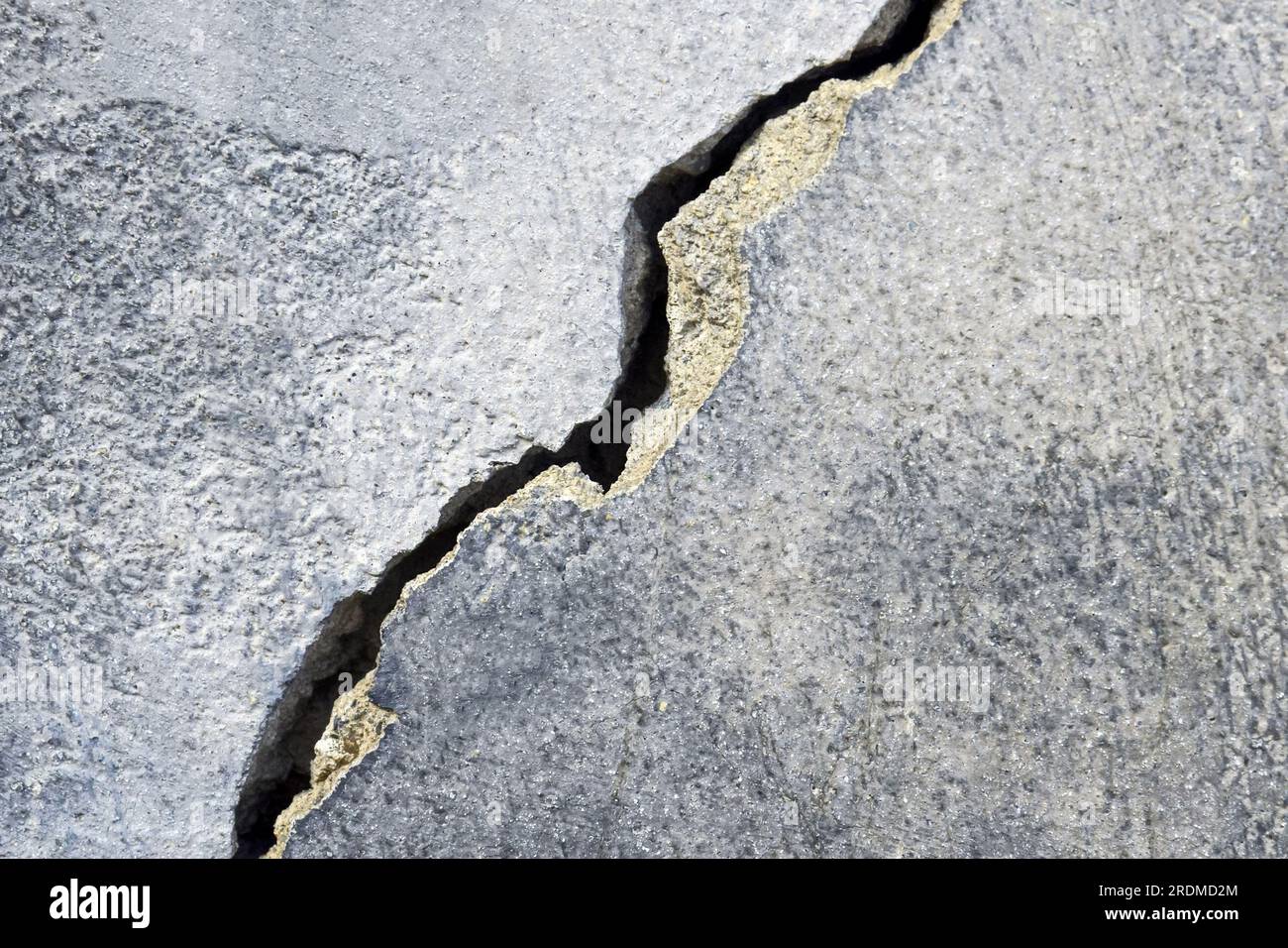 Großer Riss an der alten Putzwand. Lange Wicklungen, aufsteigender Riss in der Zementoberfläche eines alten Gebäudes. Speicherplatz kopieren. Selektiver Fokus. Stockfoto Großer Riss an der alten Putzwand. Lange Wicklungen, aufsteigender Riss in der Zementoberfläche eines alten Gebäudes. Speicherplatz kopieren. Selektiver Fokus. Stockfoto