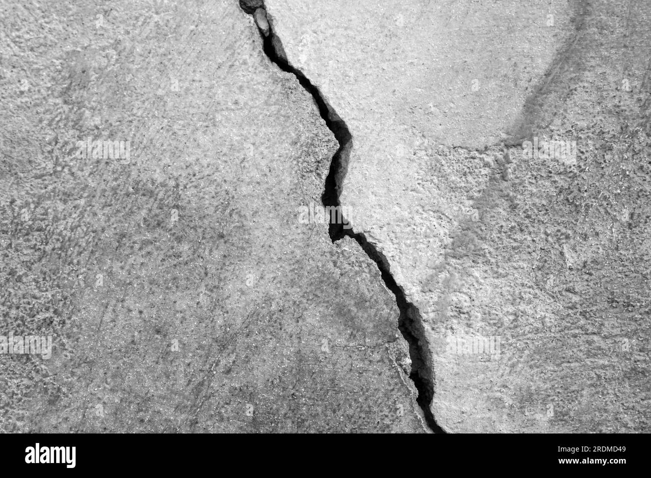 Großer Riss an der alten Putzwand. Langer Wicklungsriss in der Zementoberfläche eines alten Gebäudes. Schwarzweißfoto. Speicherplatz kopieren. Selektiver Fokus. Stockfoto Großer Riss an der alten Putzwand. Langer Wicklungsriss in der Zementoberfläche eines alten Gebäudes. Schwarzweißfoto. Speicherplatz kopieren. Selektiver Fokus. Stockfoto