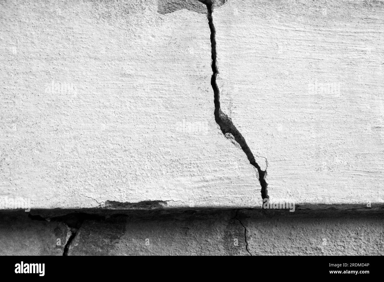 Großer Riss an der alten Putzwand. Langer Wicklungsriss in der Zementoberfläche eines alten Gebäudes. Schwarzweißfoto. Speicherplatz kopieren. Selektiver Fokus. Stockfoto Großer Riss an der alten Putzwand. Langer Wicklungsriss in der Zementoberfläche eines alten Gebäudes. Schwarzweißfoto. Speicherplatz kopieren. Selektiver Fokus. Stockfoto