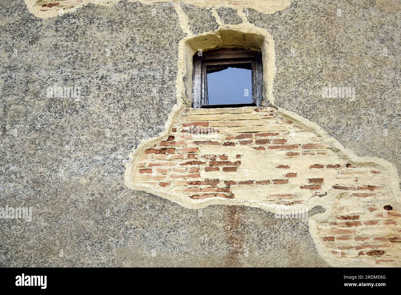 Alte Gebäudewand mit einem kleinen Vintage-Fenster. Fassadenteile in einer alten europäischen Stadt. Speicherplatz kopieren. Selektiver Fokus. Stockfoto Alte Gebäudewand mit einem kleinen Vintage-Fenster. Fassadenteile in einer alten europäischen Stadt. Speicherplatz kopieren. Selektiver Fokus. Stockfoto