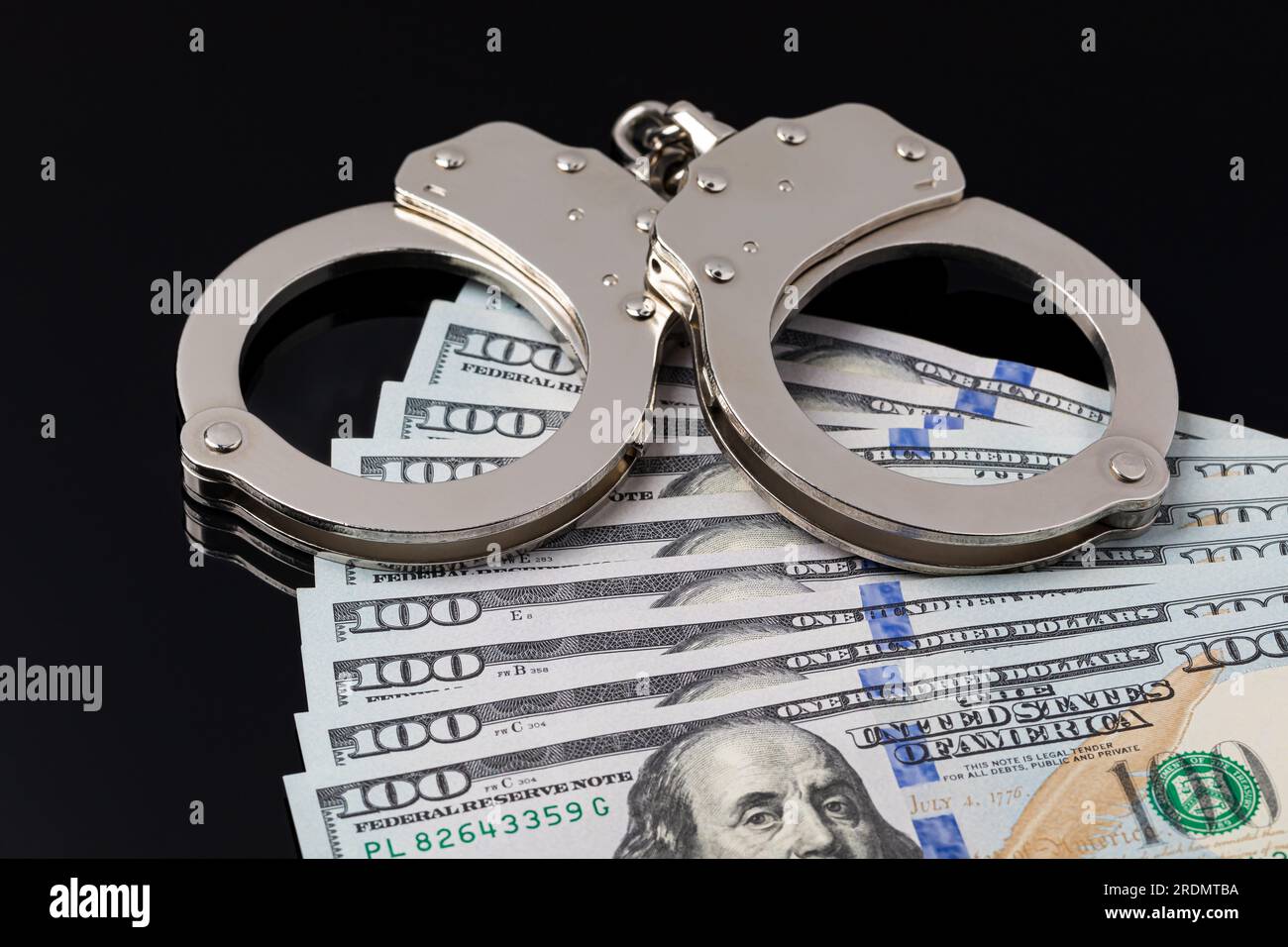 Handschellen mit Bargeld isoliert auf schwarzem Hintergrund. Reform der Bail, Bail Bond und bargeldloses Bail-Konzept. Stockfoto