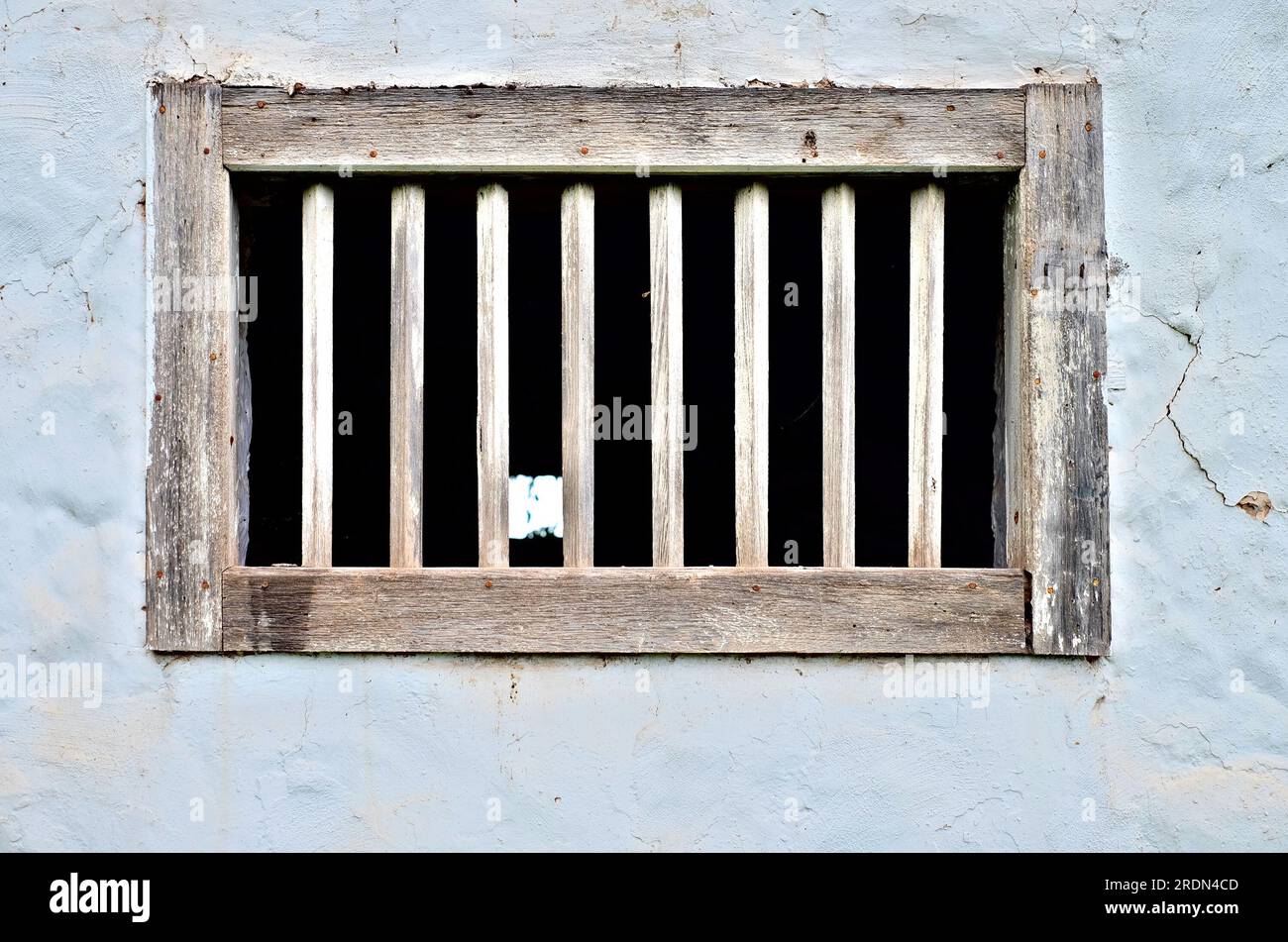 Weiße Wand und Holzfensterrahmen, Stall-, Stift- oder Scheunenarchitektur. Stockfoto