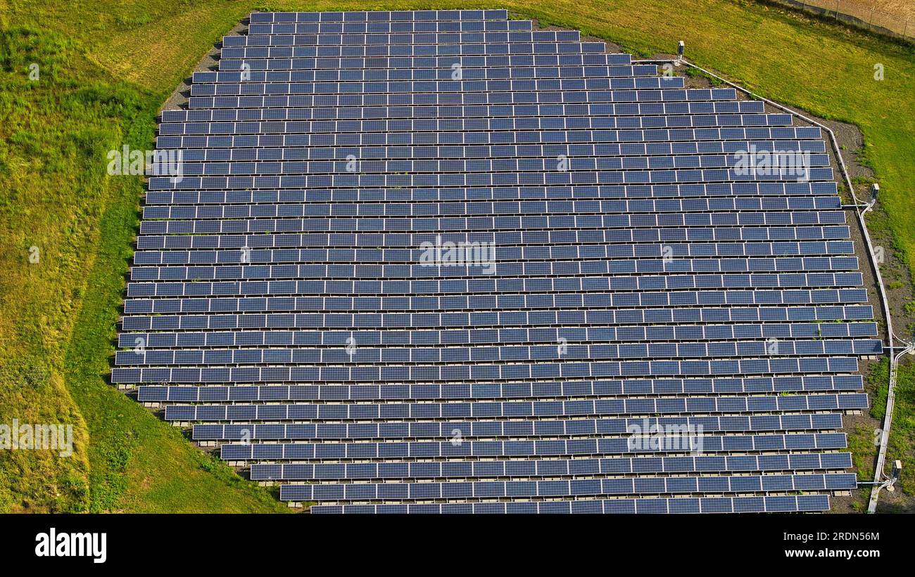 Ein Blick aus der Vogelperspektive auf eine Solaranlage in der Mitte eines Feldes Stockfoto