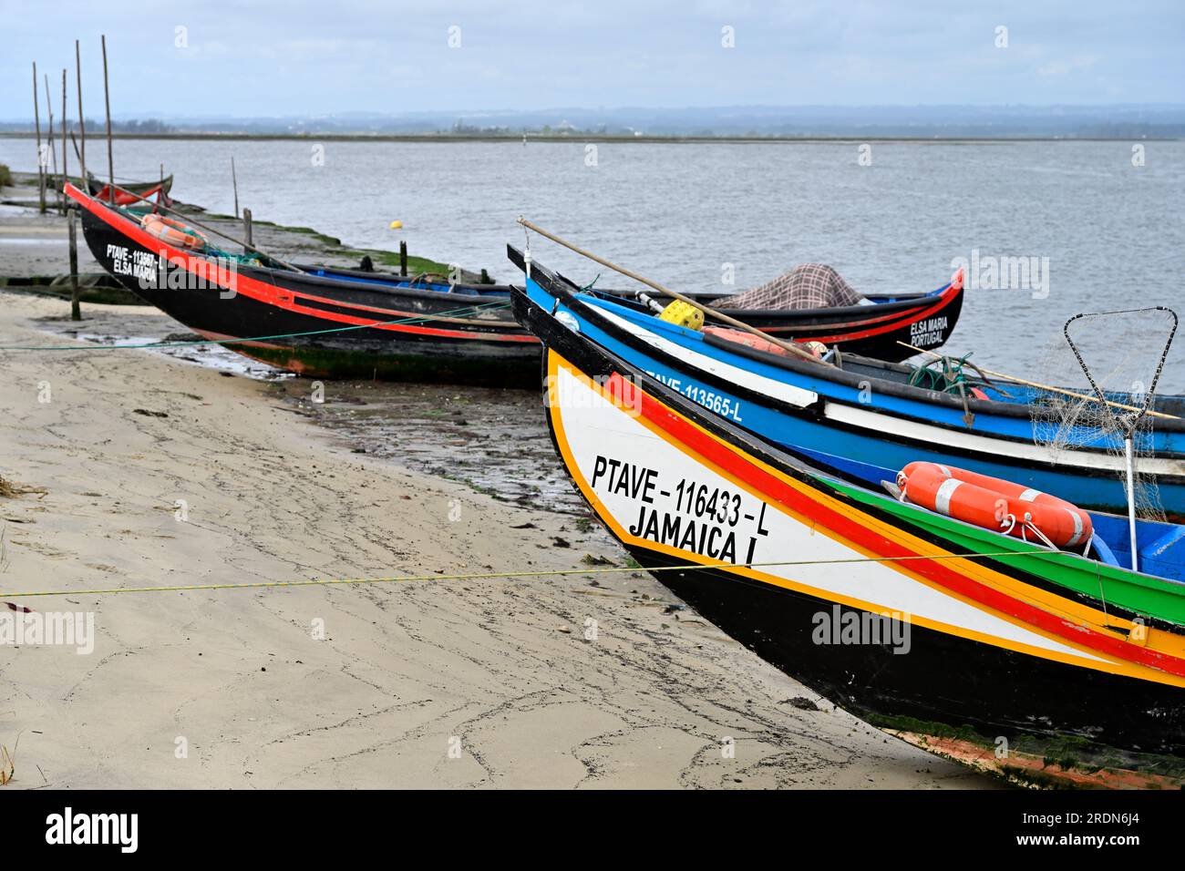 Traditionelle kleine kommerzielle Fischerboote, Moliceiros, entlang des Strandes der Aveiro Lagune Stockfoto