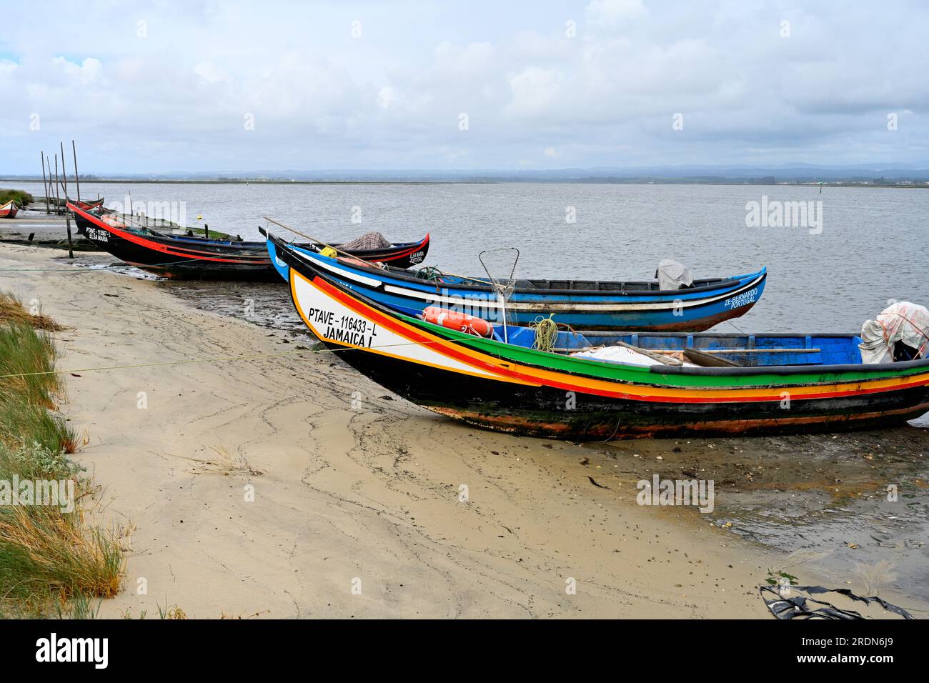 Traditionelle kleine kommerzielle Fischerboote, Moliceiros, entlang des Strandes der Aveiro Lagune Stockfoto