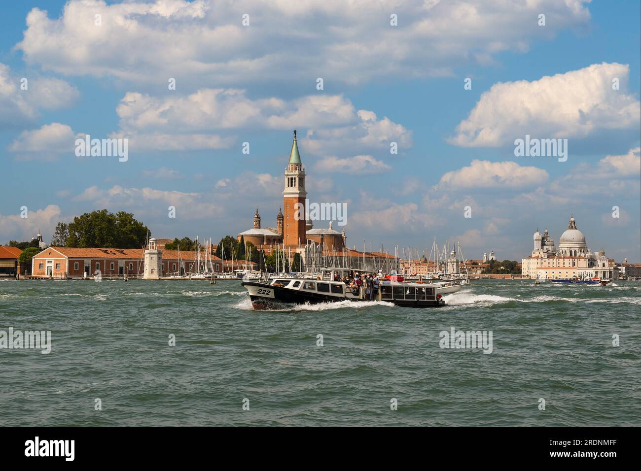 Vaporetto voller Touristen vor der Insel San Giorgio Maggiore mit dem Dorsoduro-Viertel im Hintergrund, Venedig, Venetien, Italien Stockfoto