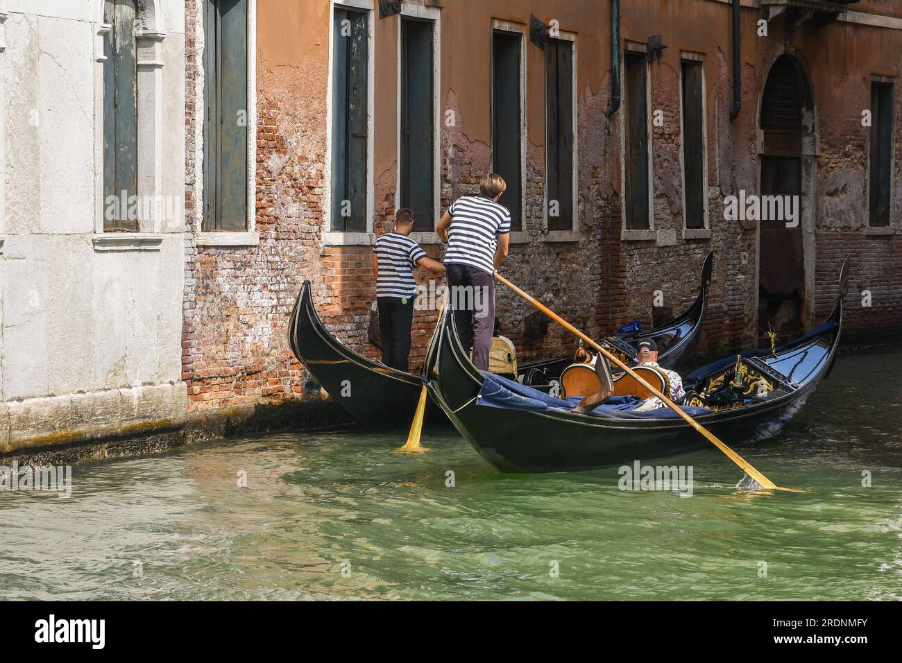 Zwei Gondeln mit Touristen auf dem Rio del Fondaco dei Tedeschi, nicht weit von der Rialtobrücke entfernt, im Sommer Venedig, Venetien, Italien Stockfoto