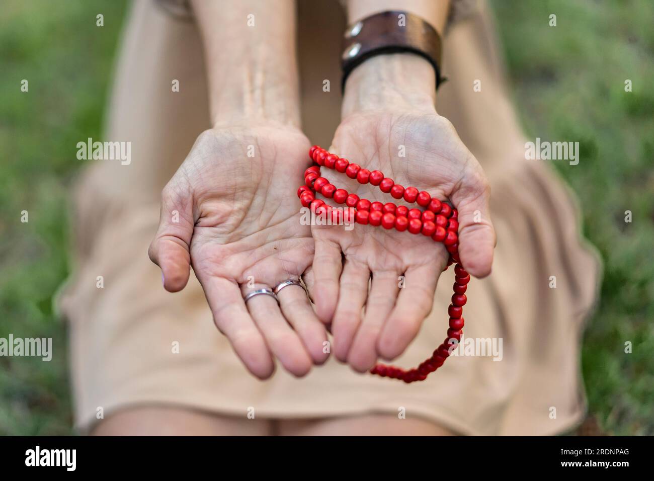 Nahaufnahme von geöffneten Frauenhänden mit einer japa mala Stockfoto