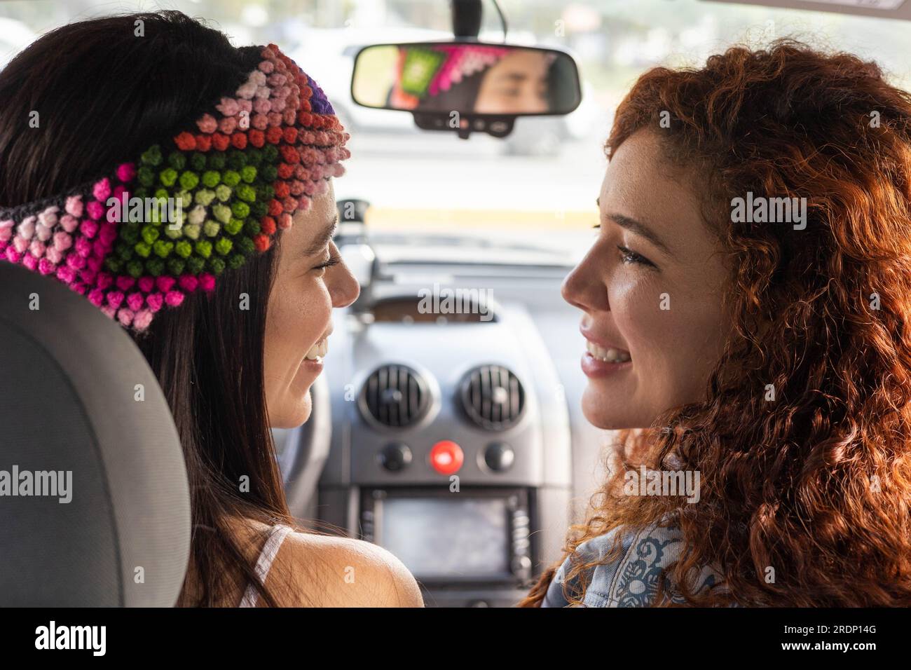 Sie sehen sich mit Liebe an, zwei junge Frauen in einem Auto, reisen als romantische Aktivität und als Paar, Lifestyle und Transport Stockfoto