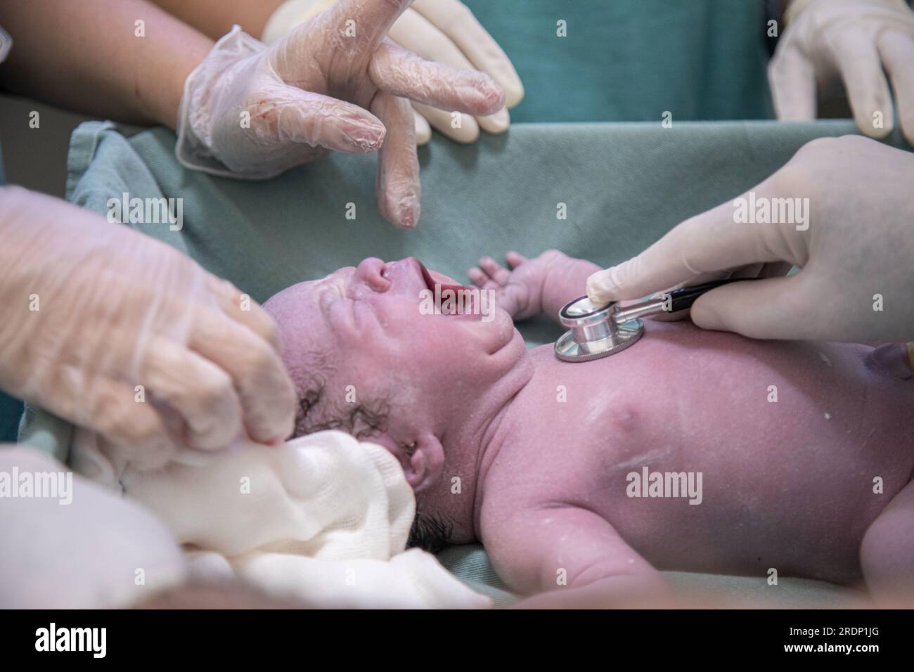 Neugeborene, die mit dem Stethoskop ärztlich untersucht werden Stockfoto