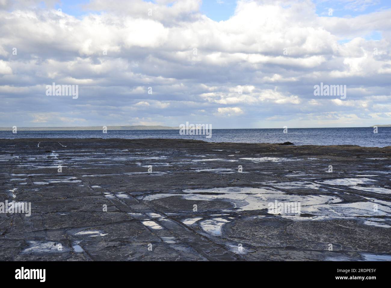 Ruhige Winterszene: Schöne Küstenlandschaft mit schneebedeckten Küstenabschnitten und klarem Horizont Stockfoto