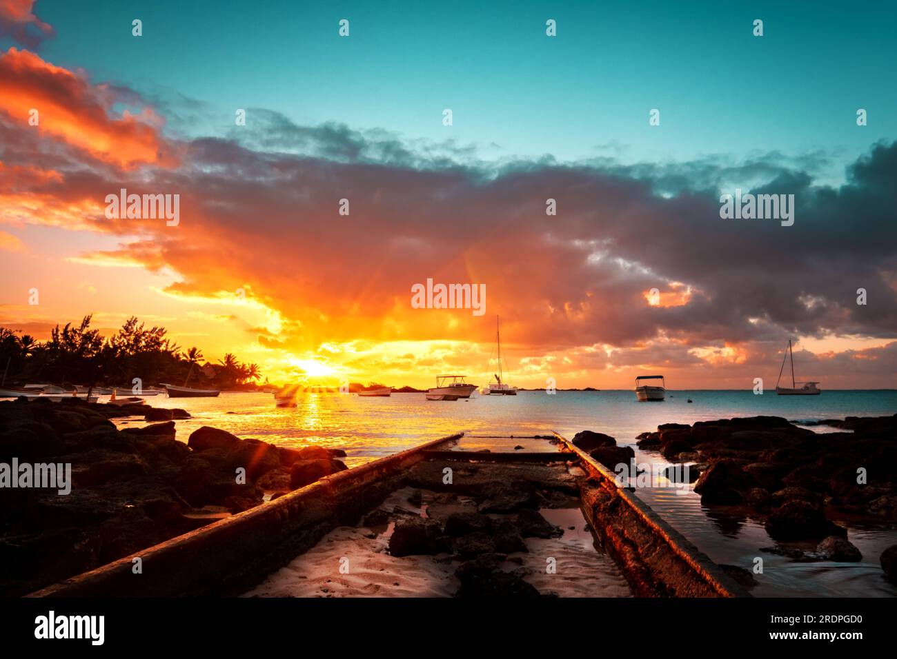 Strand bei Sonnenaufgang oder Sonnenuntergang, auf Mauritius, mit weißem Sand und einem tollen Holzsteg Stockfoto