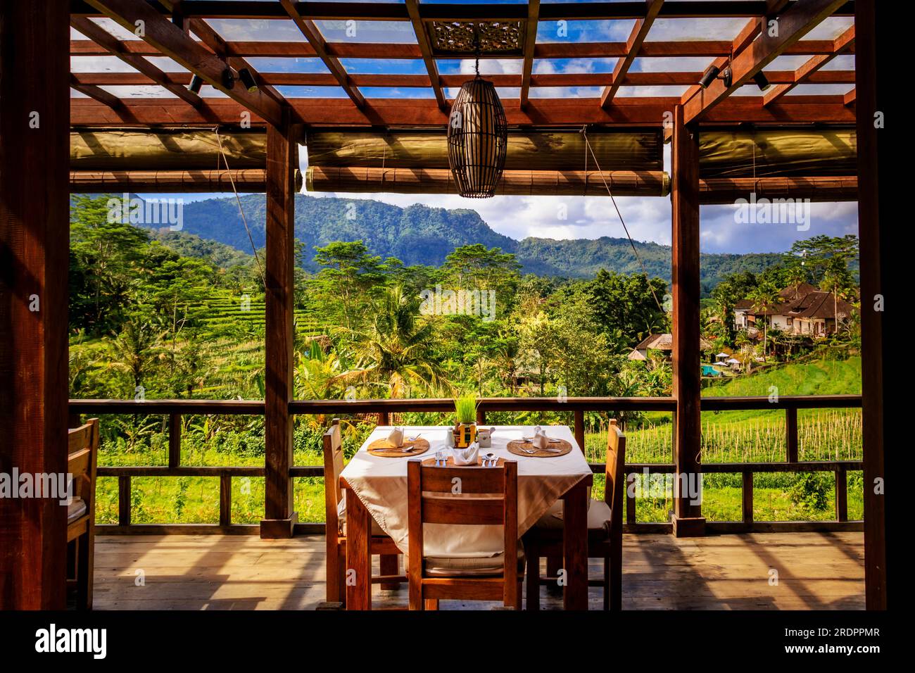 Tisch und Stühle im Café auf bali in Siedemen. Schöne Aussicht auf die Reisfelder beim Essen und beim Frühstück. Sie können sich keinen schöneren Ort vorstellen Stockfoto