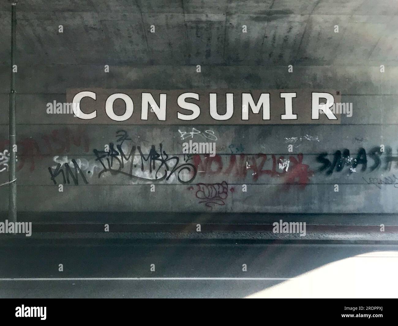 Straßenkunst in einer Unterführung in Berlin mit dem Wort CONSUMIR in Großbuchstaben. Stockfoto