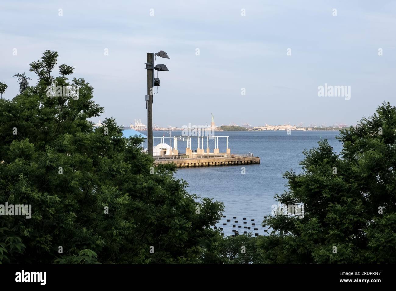 Blick auf die Freiheitsstatue vom Brooklyn Bridge Park, einem Park auf der Brooklyn-Seite des East River in New York City. Stockfoto