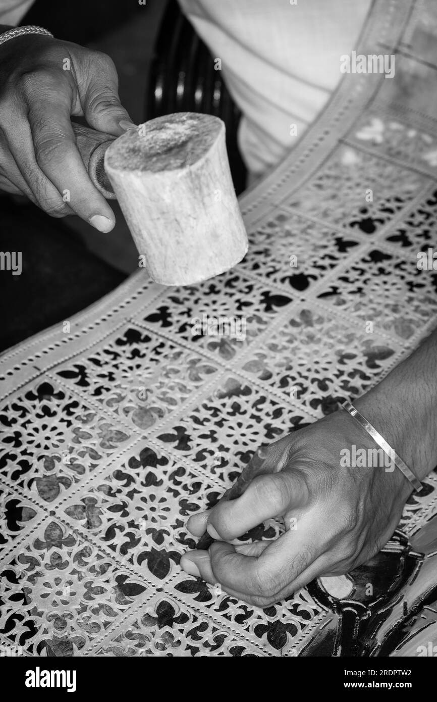 Kunsthandwerkerin, die traditionelle Büffelleder-Schnitzkunst in indonesien herstellt Stockfoto