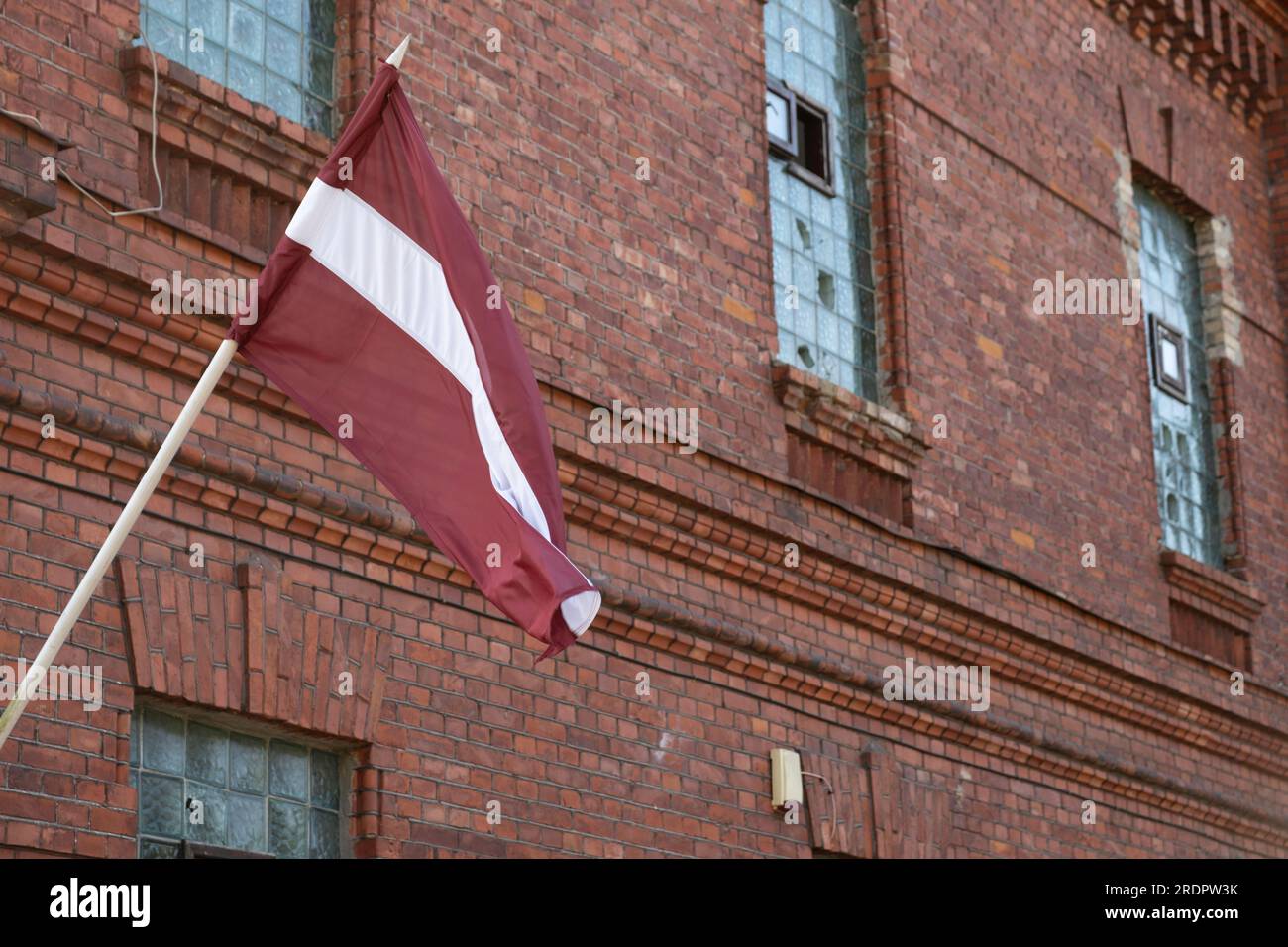 Die lettische Nationalflagge fliegt vor dem Karosta-Gefängnismuseum am ehemaligen russischen kaiserlichen und sowjetischen Marinestützpunkt an der Ostsee Stockfoto