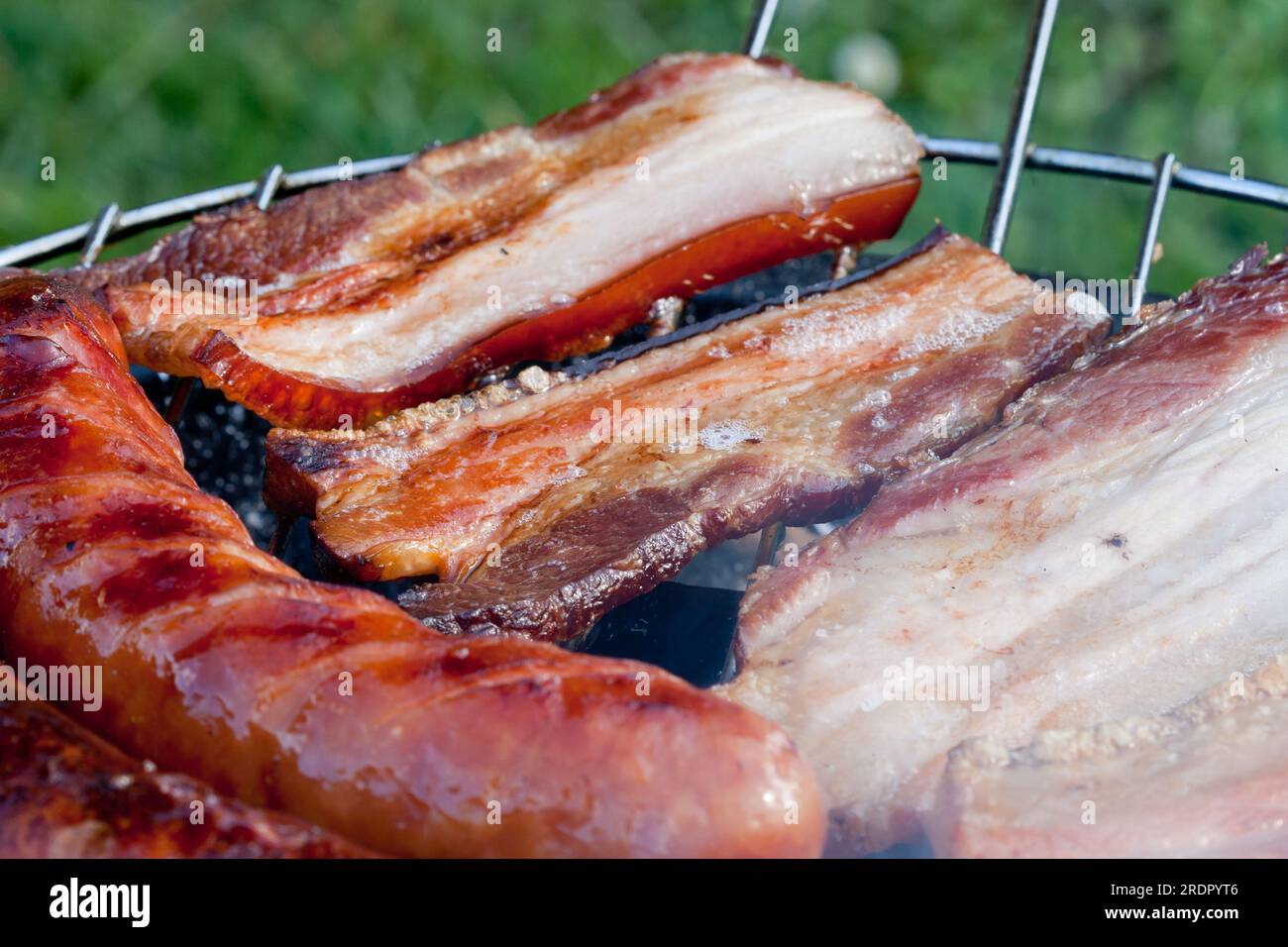 Würstchen und Speck auf dem Grill Stockfoto