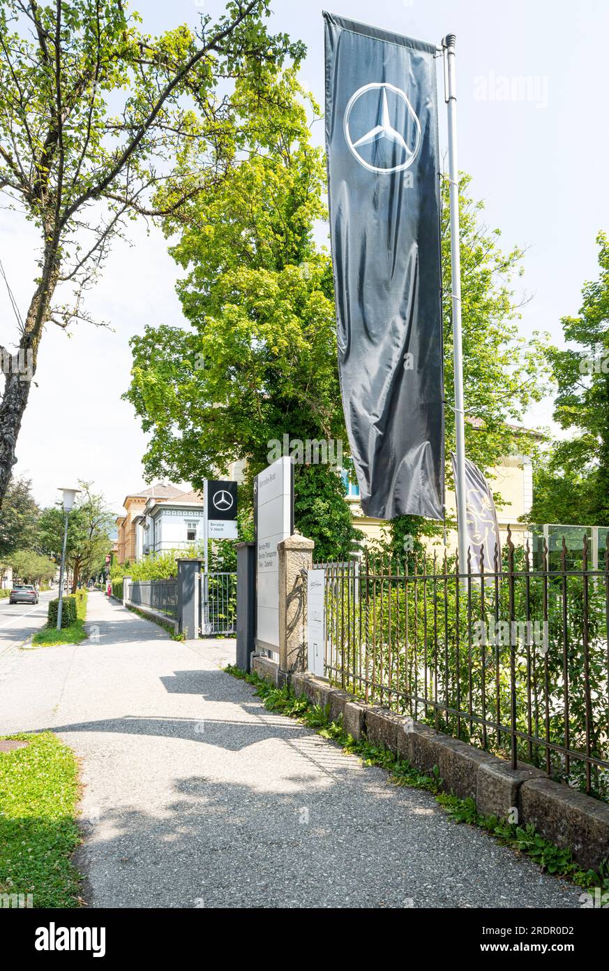 Villach, Österreich. Juli 18 2023. Eine Flagge mit dem Mercedes-Benz-Symbol über dem Eingang zu einem Autohändler im Stadtzentrum Stockfoto