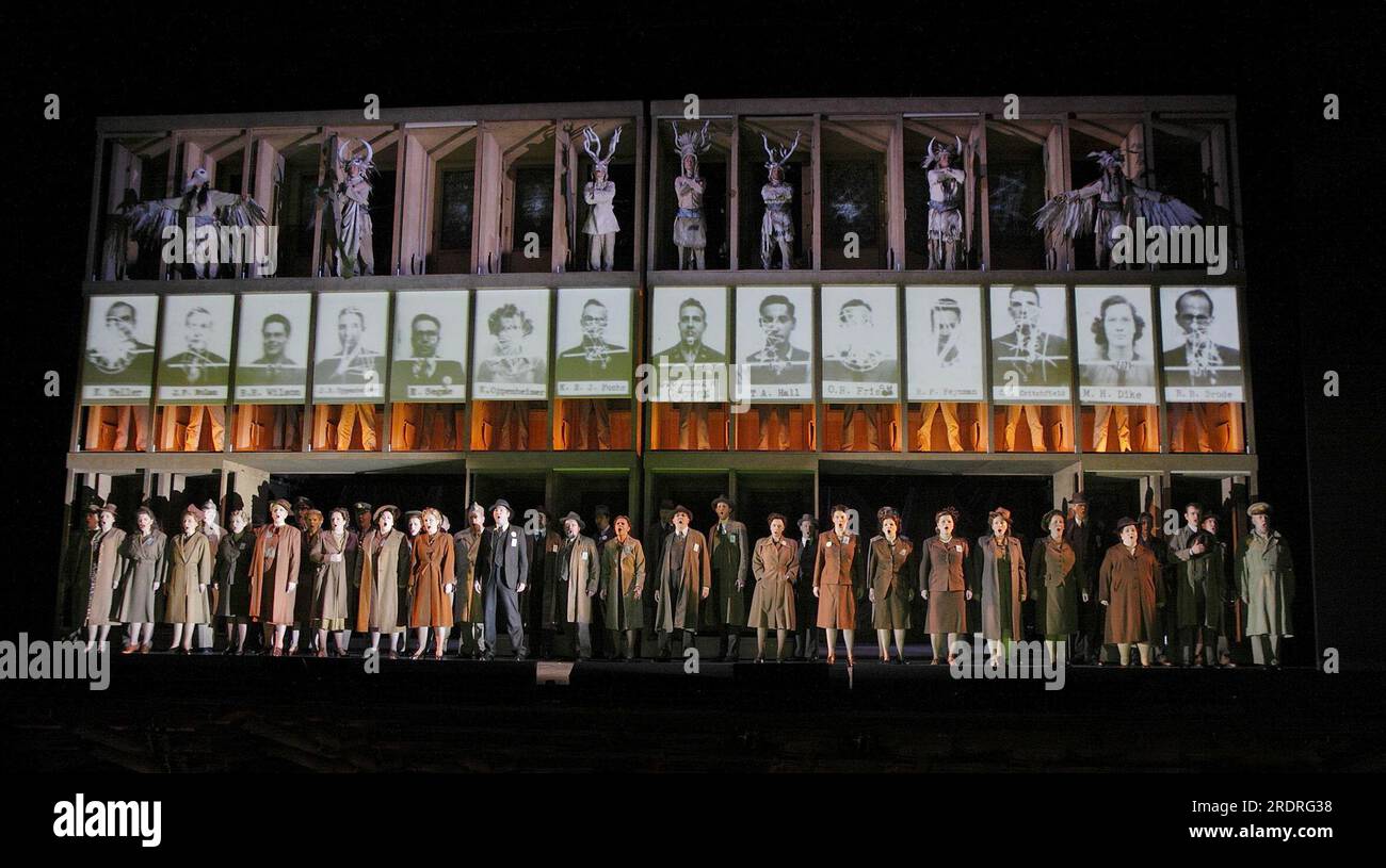 Auf der Bühne Chor von Manhattan Project Physikern mit ihren Fotos zusammen mit den Fotos von indianischen Ureinwohnern in DOCTOR ATOMIC an der English National Opera (ENO), London Coliseum WC2 25/02/2009 eine Koproduktion mit der Metropolitan Opera, New York Musik: John Adams libretto: Peter Sellars Dirigent: Lawrence Renes Set Design: Julian Crouch Kostüme, Catherine Zuber Beleuchtung, Brian MacDevitt Regisseur: Penny Woolcock Stockfoto