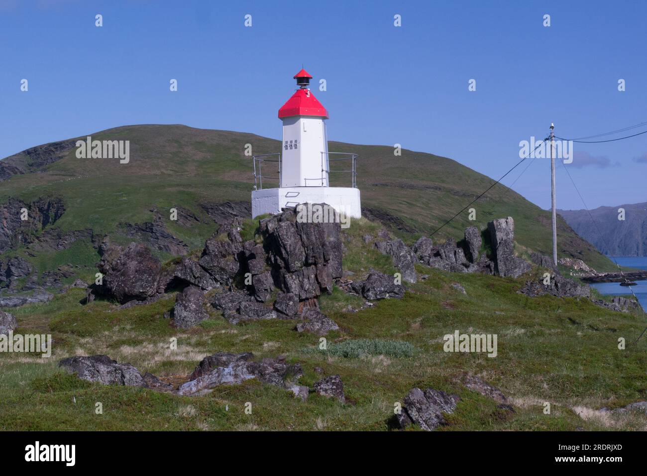 Kleiner Leuchtturm Kamøyfjord auf einem Hügel auf der Halbinsel Hjalmarneset an der Nordseite des schönen Fischerdorfes Kamøyvær Nordkapp Stockfoto