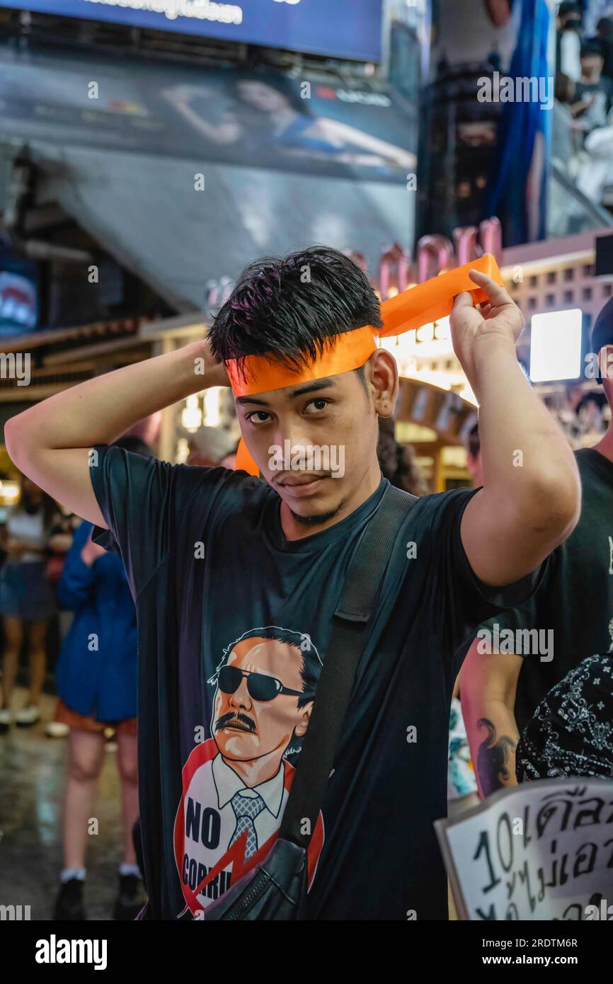 Bangkok, Thailand. 23. Juli 2023. Ein Unterstützer von Pita Limjaroenrat trägt ein symbolisches orangefarbenes Band und ein T-Shirt mit dem Gesicht von Chuwit Kamolvisit während einer Demonstration an der Kreuzung von Asoke. Der politische Aktivist Sombat Boonngamanong, auch bekannt als ‚Bor Kor Lai Jud‘, organisierte eine Demonstration gegen den Senat, weil er Pita Limjaroenrats Versuch, Ministerpräsident zu werden, nicht unterstützte. Kredit: SOPA Images Limited/Alamy Live News Stockfoto