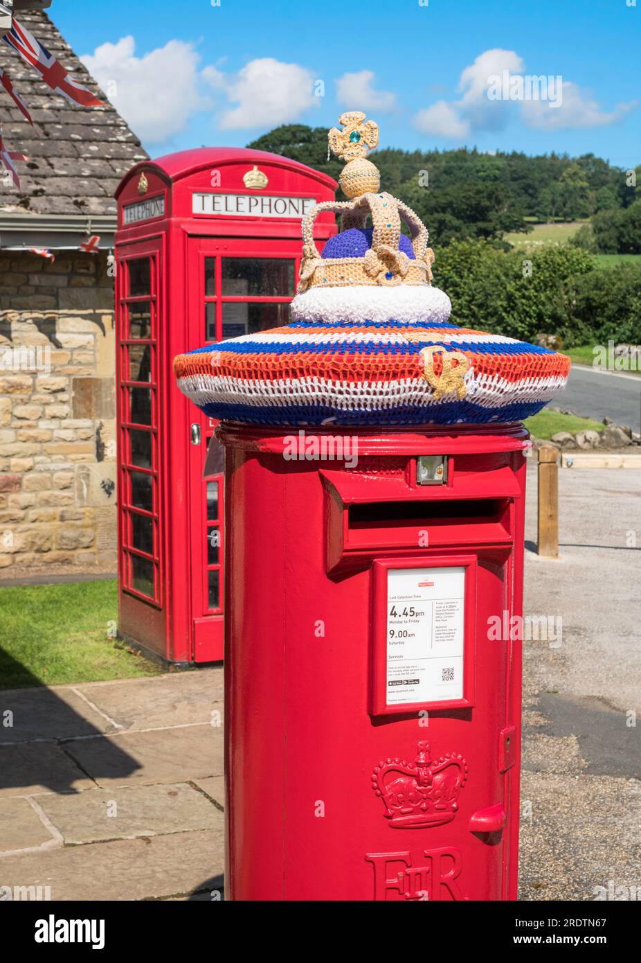 Gestrickte Gedenkkrone zur Feier der Krönung des Königs über einem roten Briefkasten in England, Großbritannien Stockfoto