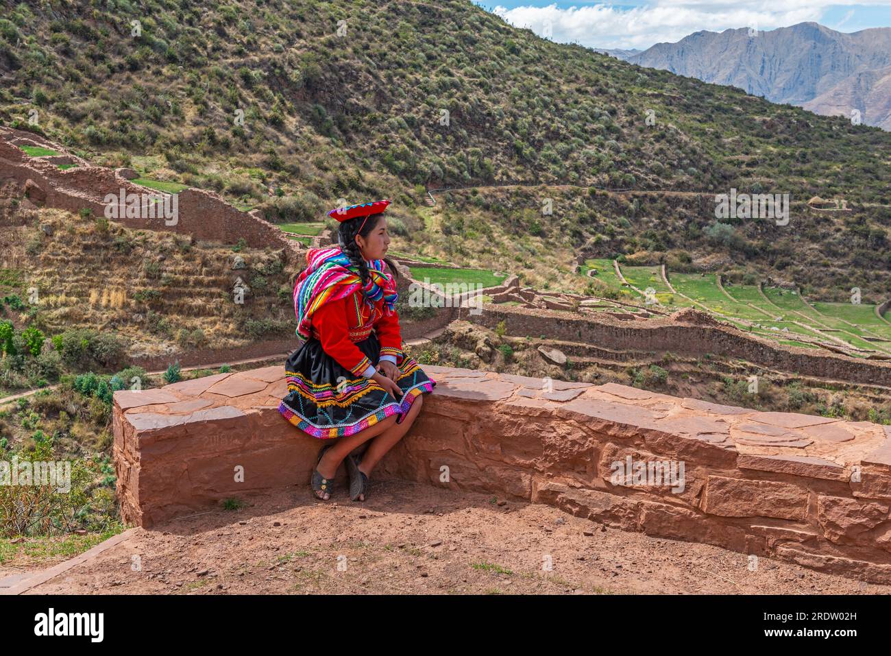 Die einheimische Frau von Quechua auf der Inka-Mauer in traditioneller Kleidung, Tipon, Cusco, Peru. Stockfoto