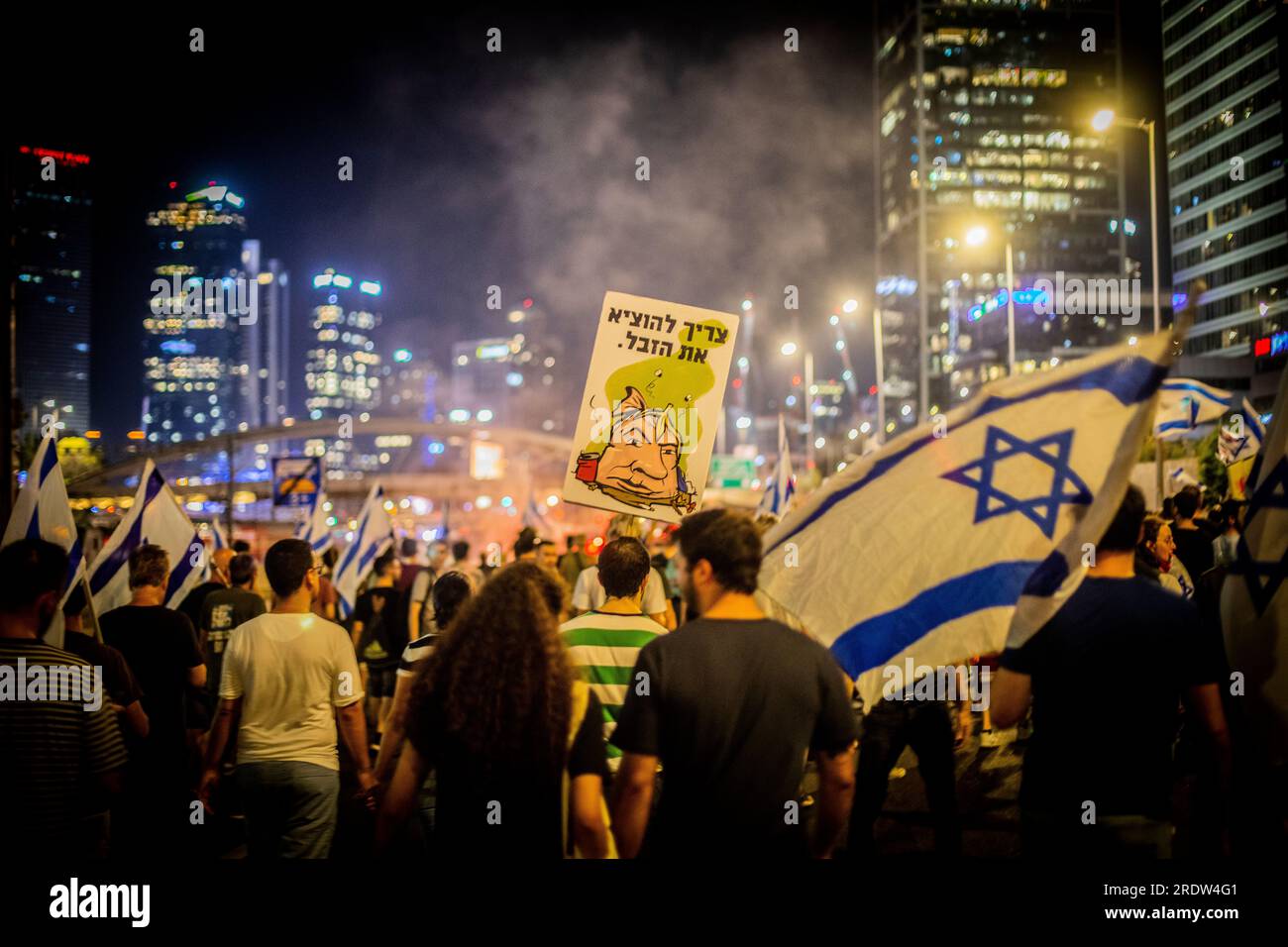 Die Demonstranten halten ein hebräisches Schild mit der Aufschrift " müssen den Müll rausbringen" und zeigen einen Cartoon des israelischen Ministerpräsidenten Benjamin Netanjahu als Müllsack während einer Demonstration in Tel Aviv am Donnerstag, den 20 2023. Juli. Der israelische Ministerpräsident Benjamin Netanjahu schwor am Donnerstag, trotz beispielloser Massenproteste im eigenen Land, wachsender Überläufer durch Militärreservisten und Appelle des US-Präsidenten, den Plan auf Eis zu legen, seine umstrittene Justizreform voranzutreiben. Nach der Rede von NetanyahuÕs blockierten die Demonstranten die Hauptstraße von Tel AvivÕs mehrere Stunden lang, zündeten Lagerfeuer an und prügelten sich Stockfoto