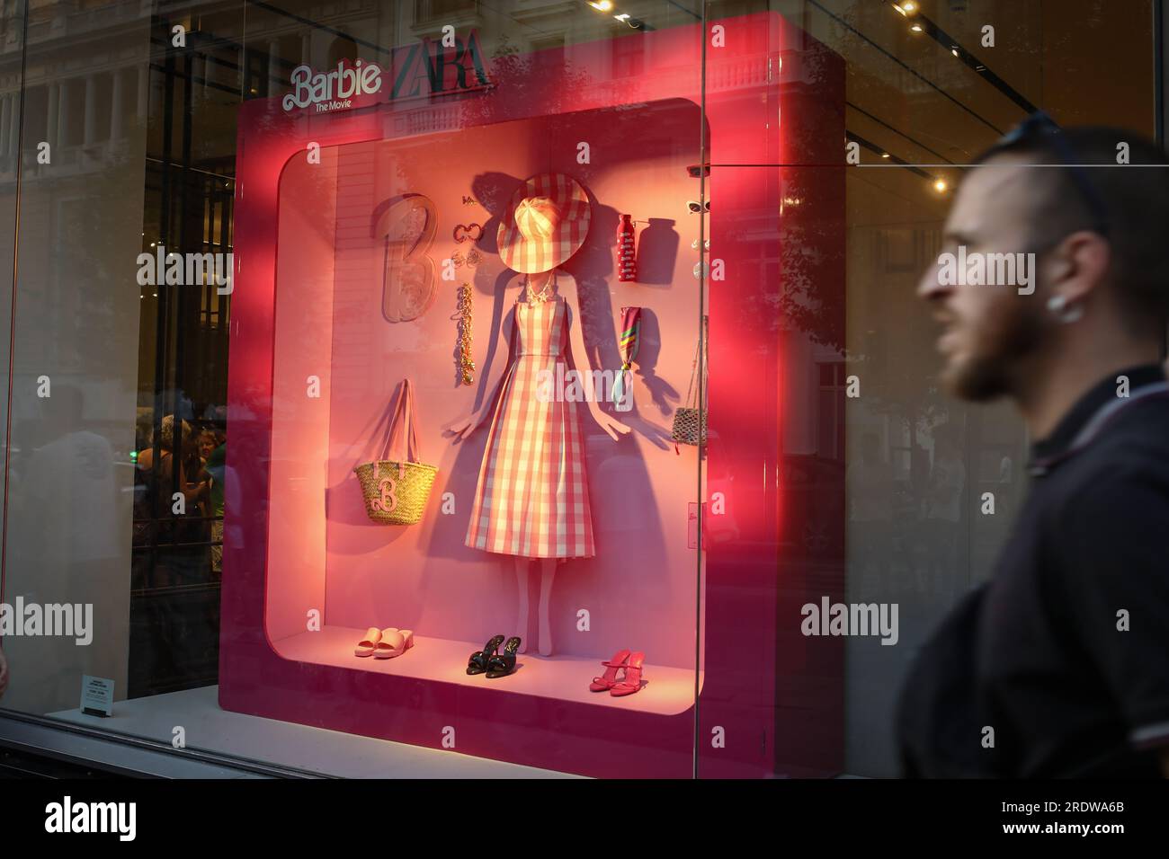 Madrid, Spanien. 22. Juli 2023. Ein Mann kommt vor dem Fenster des Zara-Shops auf Madrids Gran VÃ-A Straße vorbei, mit einer Barbie Werbekampagne für die Premiere eines neuen Films über die weltberühmte Puppe. (Credit Image: © David Canales/SOPA Images via ZUMA Press Wire) NUR ZUR REDAKTIONELLEN VERWENDUNG! Nicht für den kommerziellen GEBRAUCH! Stockfoto