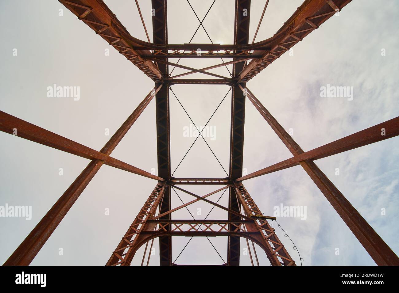 Eisenbrücke aus rostfreiem Metall, nach oben gerichteter Schuss des Himmels durch geometrische Balken Stockfoto