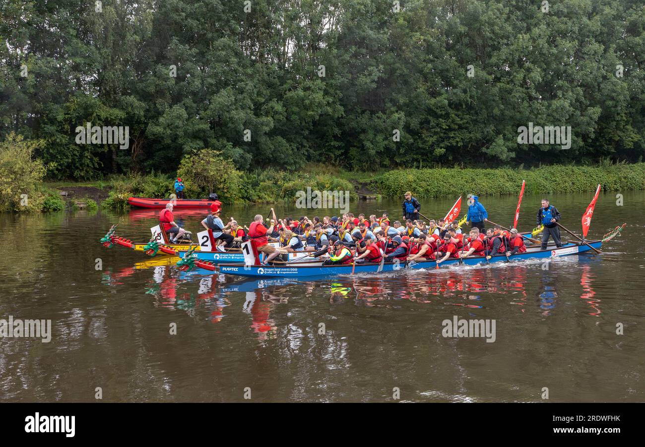 River Mersey, Warrington, Cheshire, Großbritannien. 23. Juli 2023. Ein Dragon Boat Festival am Fluss Mersey in Warrington. Im Ruderclub und trotz des durchgehend regnerischen Tages wetteiferten sich einige Drachenboote um einen Gewinner. Ziel der Veranstaltung war es, Gelder für das St. Rocco's Hospice zu sammeln, das es ist, eine hochwertige Versorgung und Unterstützung für Menschen und ihre Angehörigen mit lebenslimitierenden Krankheiten, die in der Region Warrington leben, zu bieten, damit jede Person Komfort, Hoffnung, Kraft und Frieden finden kann. Kredit: John Hopkins/Alamy Live News Stockfoto