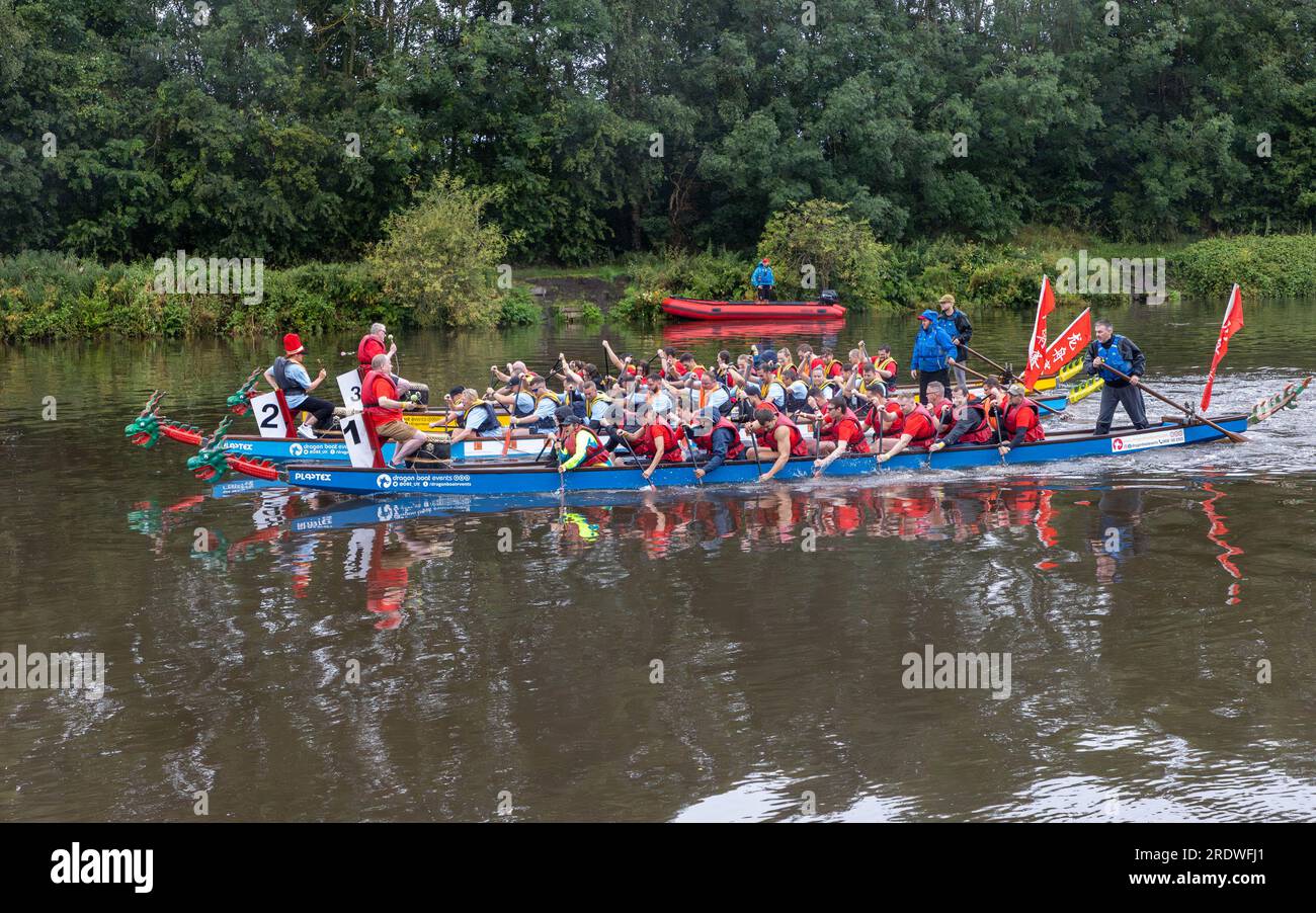 River Mersey, Warrington, Cheshire, Großbritannien. 23. Juli 2023. Ein Dragon Boat Festival am Fluss Mersey in Warrington. Im Ruderclub und trotz des durchgehend regnerischen Tages wetteiferten sich einige Drachenboote um einen Gewinner. Ziel der Veranstaltung war es, Gelder für das St. Rocco's Hospice zu sammeln, das es ist, eine hochwertige Versorgung und Unterstützung für Menschen und ihre Angehörigen mit lebenslimitierenden Krankheiten, die in der Region Warrington leben, zu bieten, damit jede Person Komfort, Hoffnung, Kraft und Frieden finden kann. Kredit: John Hopkins/Alamy Live News Stockfoto