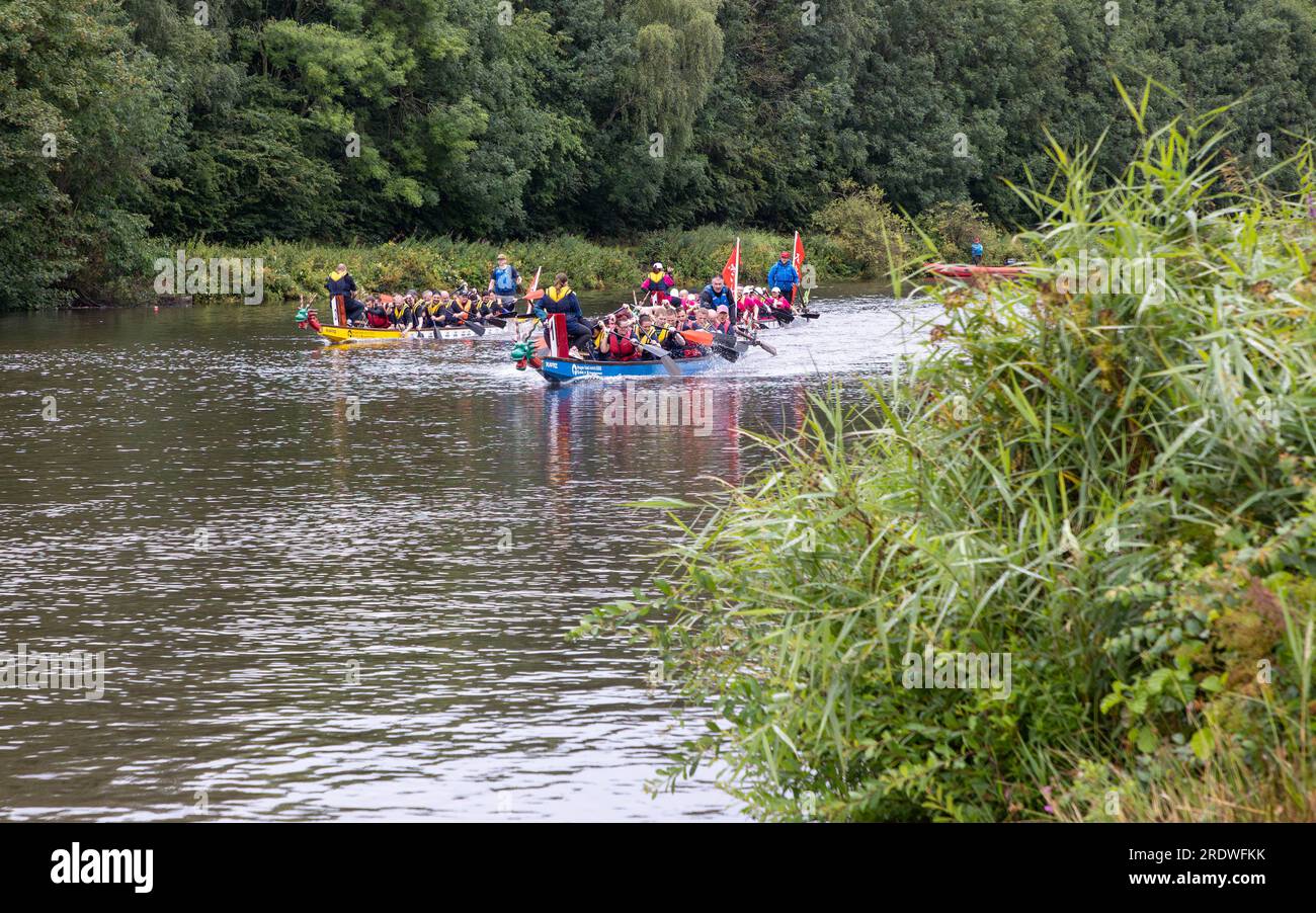 River Mersey, Warrington, Cheshire, Großbritannien. 23. Juli 2023. Ein Dragon Boat Festival am Fluss Mersey in Warrington. Im Ruderclub und trotz des durchgehend regnerischen Tages wetteiferten sich einige Drachenboote um einen Gewinner. Ziel der Veranstaltung war es, Gelder für das St. Rocco's Hospice zu sammeln, das es ist, eine hochwertige Versorgung und Unterstützung für Menschen und ihre Angehörigen mit lebenslimitierenden Krankheiten, die in der Region Warrington leben, zu bieten, damit jede Person Komfort, Hoffnung, Kraft und Frieden finden kann. Kredit: John Hopkins/Alamy Live News Stockfoto