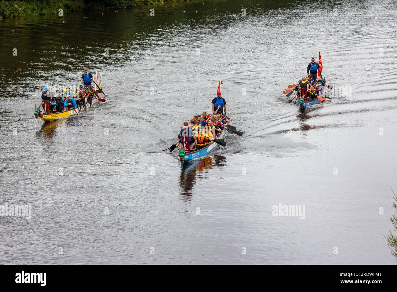 River Mersey, Warrington, Cheshire, Großbritannien. 23. Juli 2023. Ein Dragon Boat Festival am Fluss Mersey in Warrington. Im Ruderclub und trotz des durchgehend regnerischen Tages wetteiferten sich einige Drachenboote um einen Gewinner. Ziel der Veranstaltung war es, Gelder für das St. Rocco's Hospice zu sammeln, das es ist, eine hochwertige Versorgung und Unterstützung für Menschen und ihre Angehörigen mit lebenslimitierenden Krankheiten, die in der Region Warrington leben, zu bieten, damit jede Person Komfort, Hoffnung, Kraft und Frieden finden kann. Kredit: John Hopkins/Alamy Live News Stockfoto