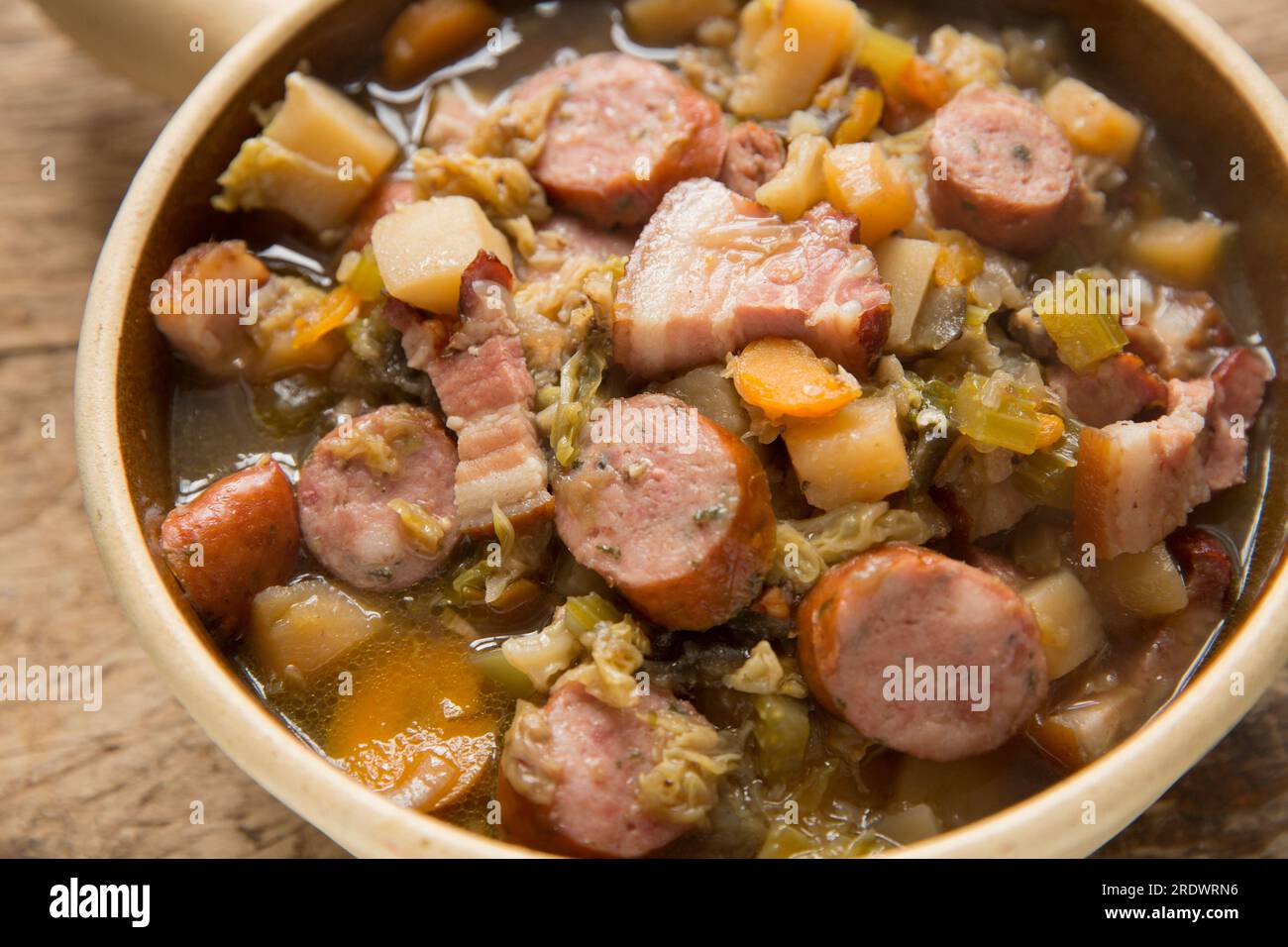 Ein hausgemachter Eintopf, der in einem langsamen Herd mit hauptsächlich Wurzelgemüse und Kohl mit Kräuterwurst und geräuchertem Speck zubereitet wird. England U Stockfoto