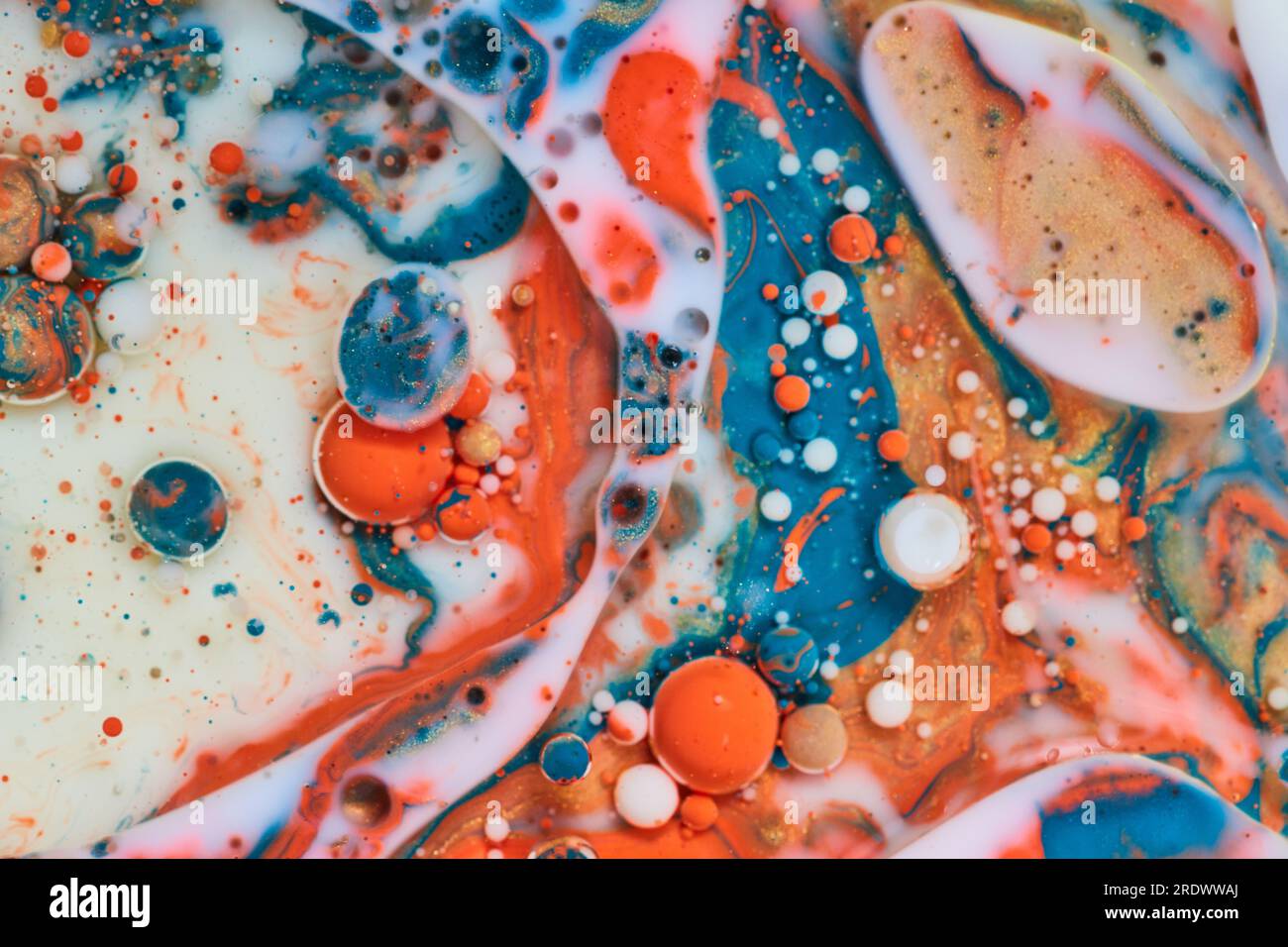Weiße Milch mit abstrakten Perlen weißer orangefarbener und blauer Blasen im Hintergrund Stockfoto