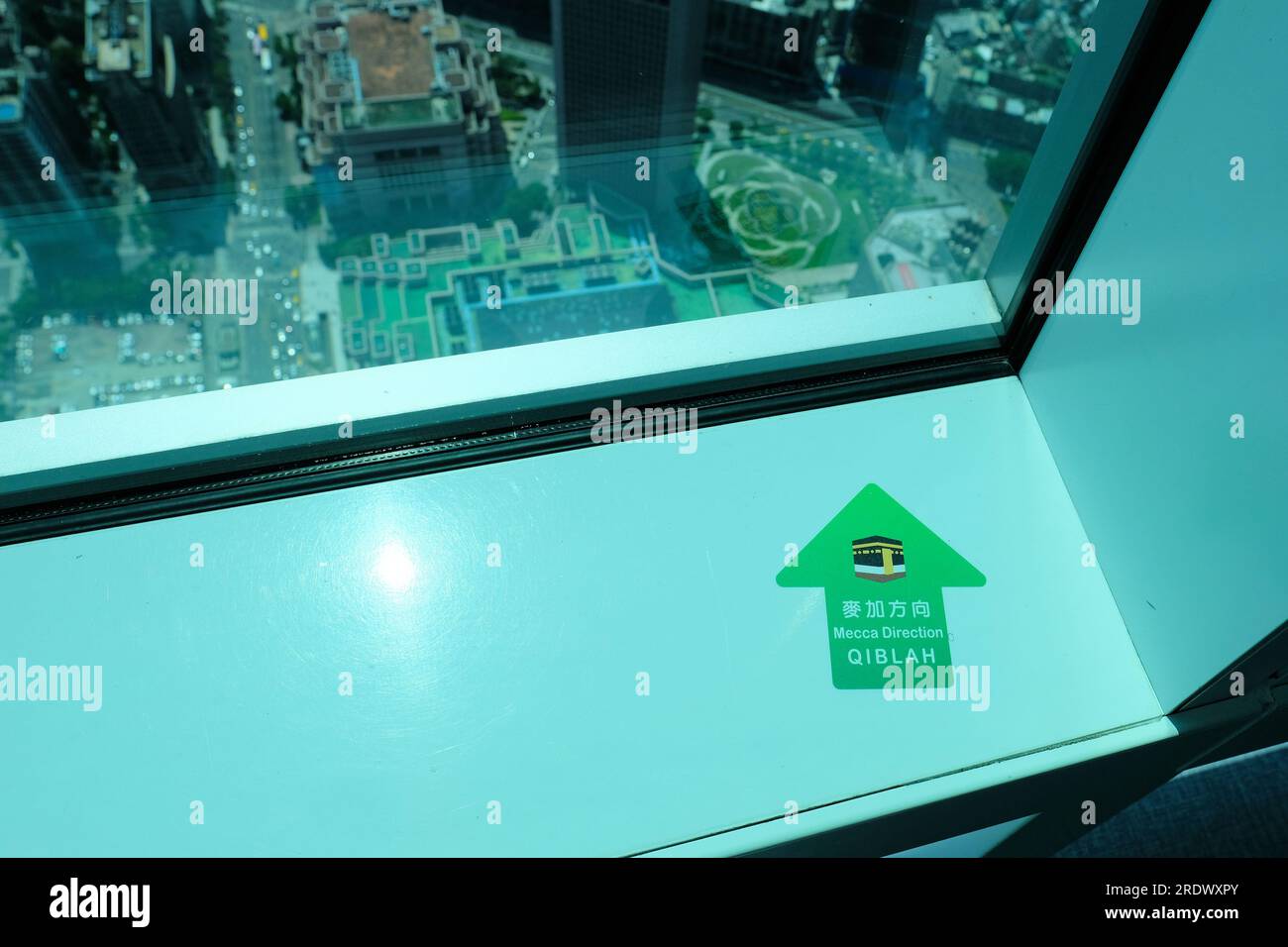 Qibla-Pfeil auf dem Fenstervorsprung, der zum Gebet in Richtung Mekka zeigt; Taipei 101 Wolkenkratzer in Taipeh, Taiwan; Religion, Glaube, Vielfalt, Einbeziehung. Stockfoto